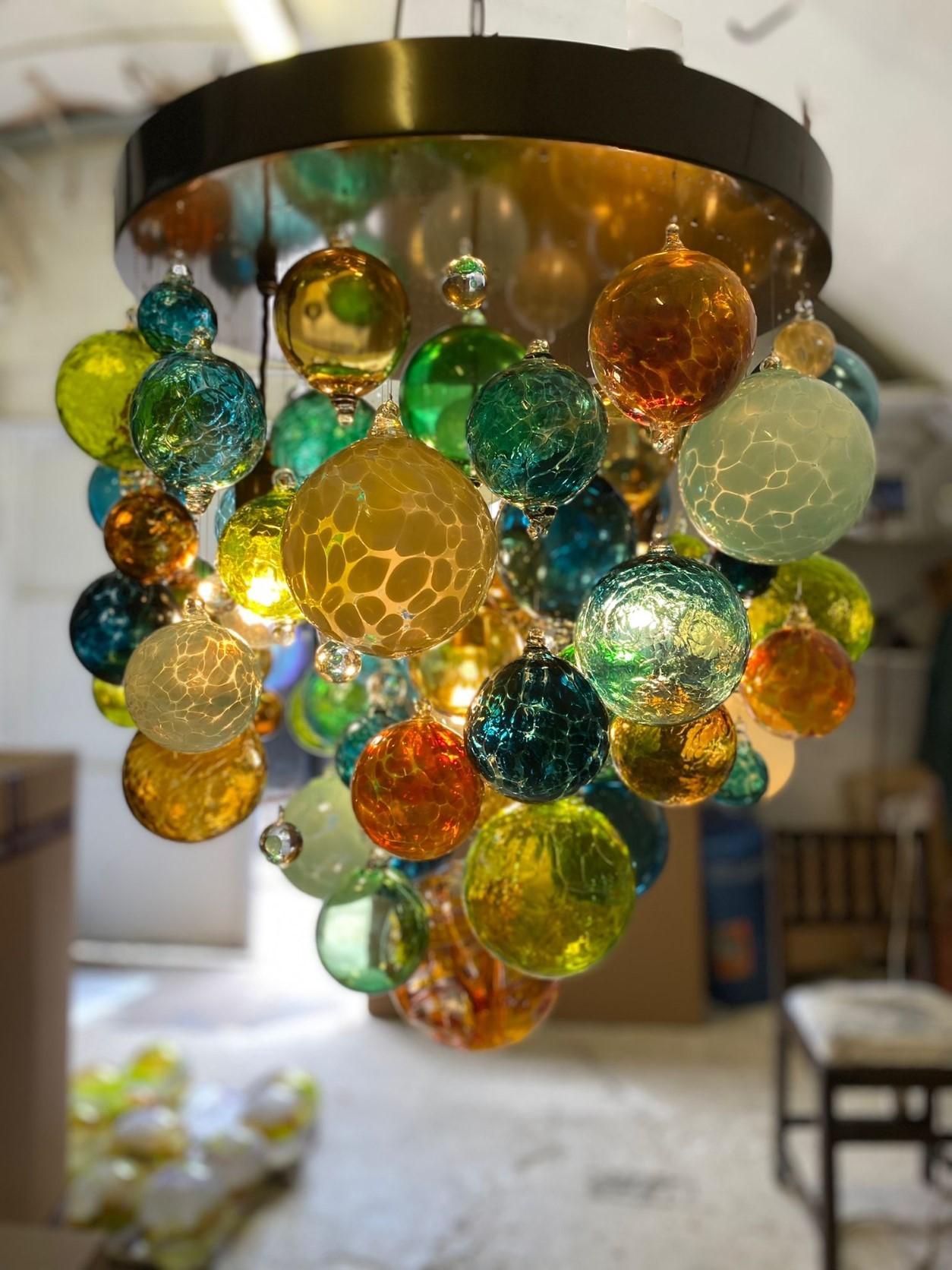 Ce lustre contemporain est un modèle Origin II et comporte plus de 50 sphères de verre soufflées individuellement. Le verre est soufflé en Europe et au Royaume-Uni et le lustre est conçu et fabriqué à la main dans notre studio du sud de Londres.