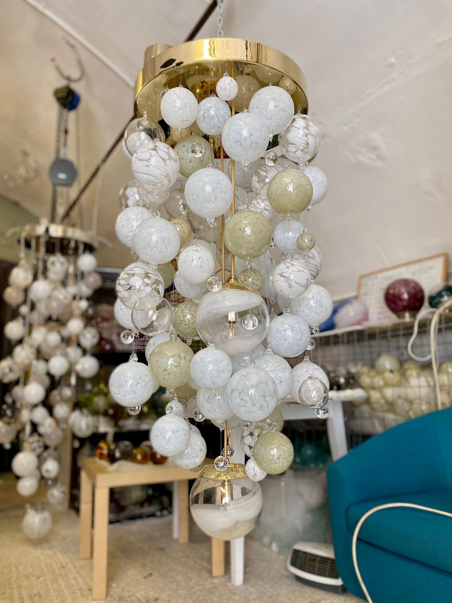 This contemporary chandelier is an Origin II design and features over 90 individually blown glass spheres. The glass is blown in Europe and the UK and the chandelier is designed and hand-crafted in our studio in London. 

This chandelier is