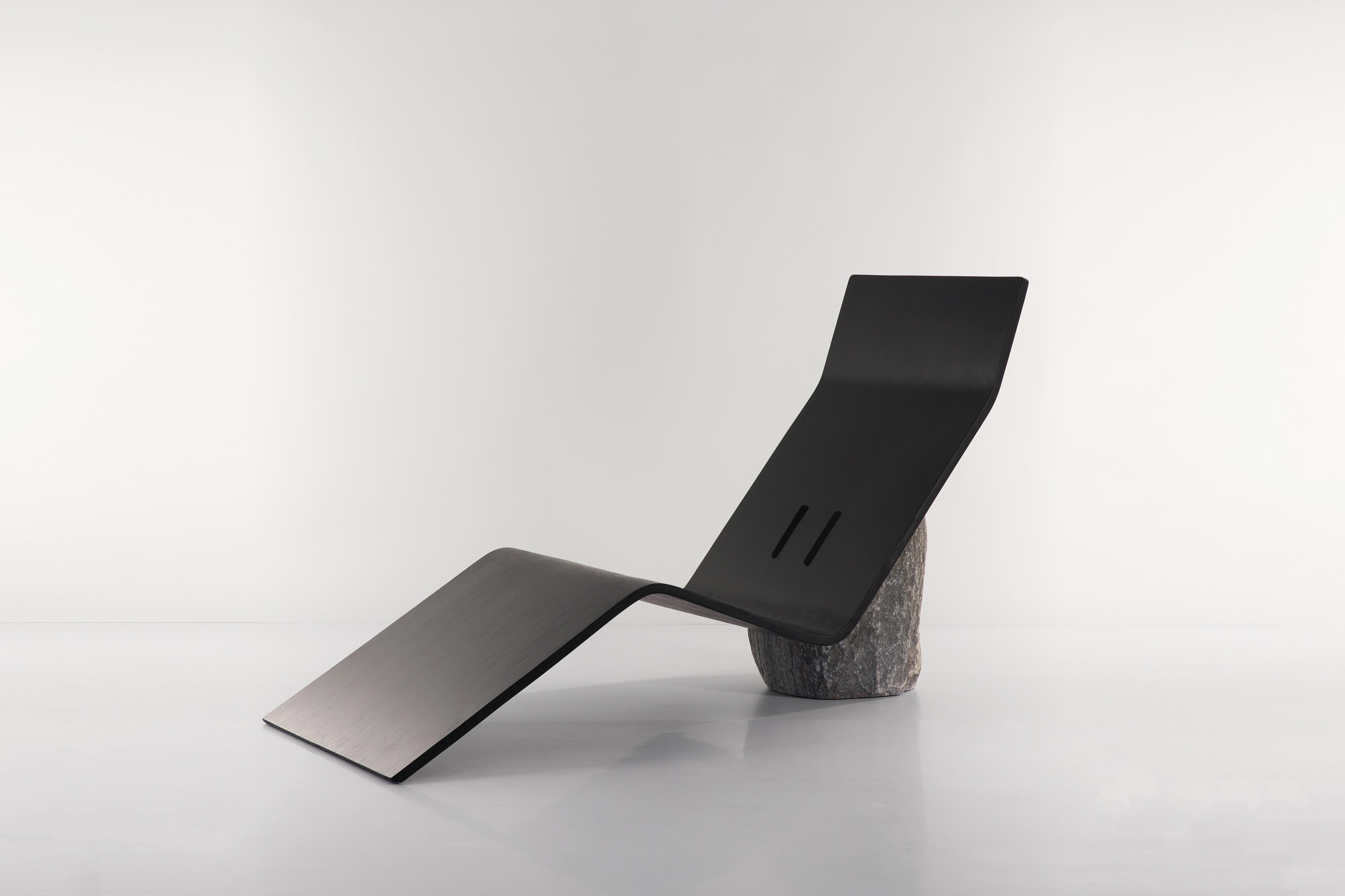 Origin Ply Chaise by Batten and Kamp
Dimensions: W170 x D 53 x H100 cm
Materials: Oak plywood, granite stone, steel fixings.

‘Origin’ and ‘Elsewhere’ are two counterpart lounge chairs. ‘Origin’ features a minimal and earthy jet black plywood seat