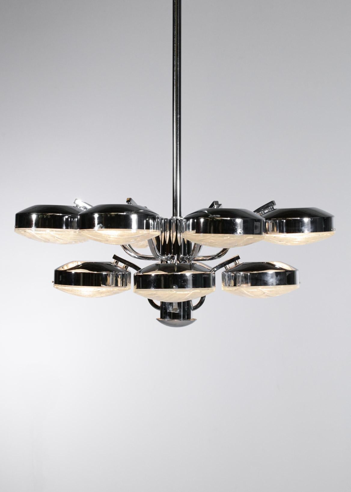 Imposing Italian chandelier from the 70's, chromed metal structure composed of twelve arms with removable thick glass diffusers. Sober and pure lines but very decorative recalling the work of Gaetano Sciolari. Very nice vintage condition, note the