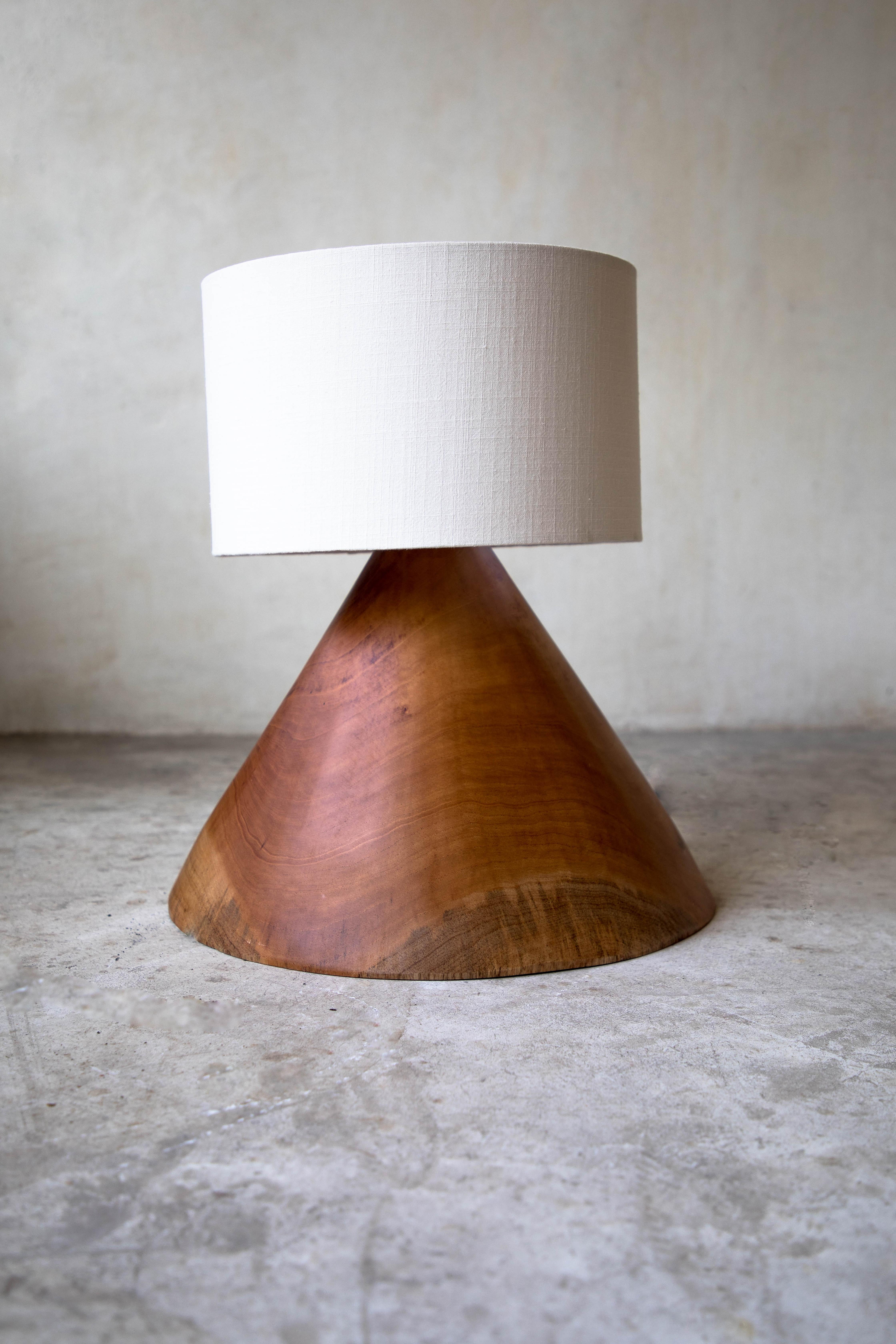 Original 08 cone table lamp with linen screen by Daniel Orozco.
Material: jabin wood, linen.
Dimensions: D 39 x H 30 cm.
Available with palm or linen lampshade.

Jabin wood cone table lamp, with palm or linen screen. Handmade by Mexican