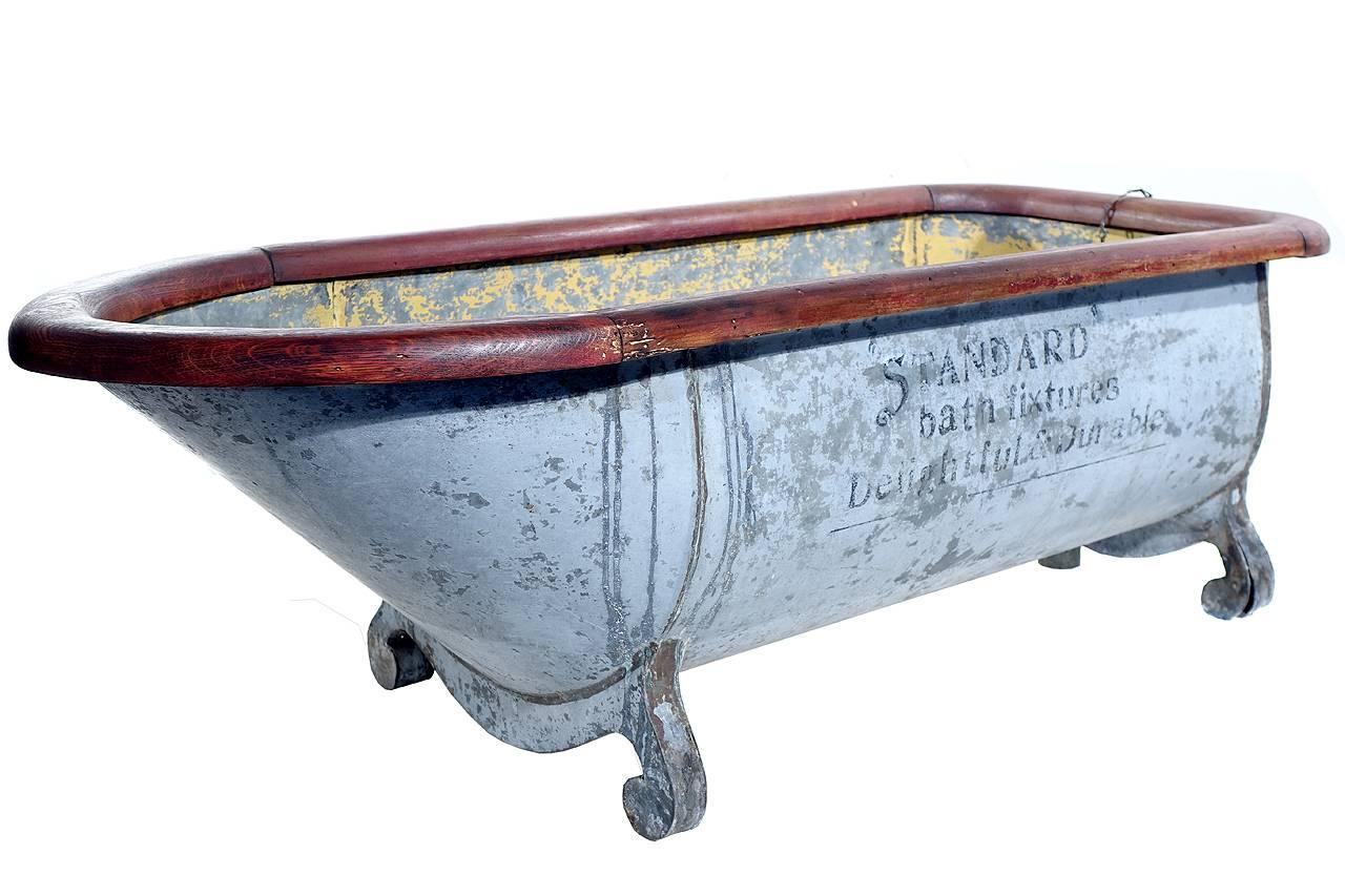 This is a very early Victorian piece of in-store advertising. It a 40 inch half scale replica of a wood rimed galvanized bath tub. It has the original bottom drain, chain and plug as well as the top overflow drain. The body is metal showing the