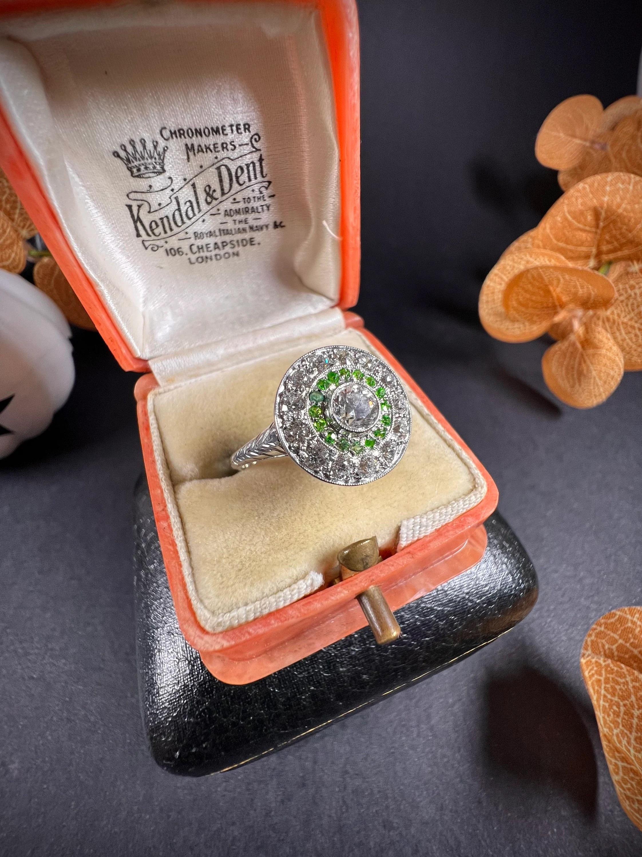 Antique Target Ring 

18ct White Gold

Circa 1910

Original, Edwardian target ring. Set with a natural, centre diamond, surrounded by gorgeous demantoid garnets & a halo of sparkling diamonds. Mounted on a white gold shank with beautifully hand