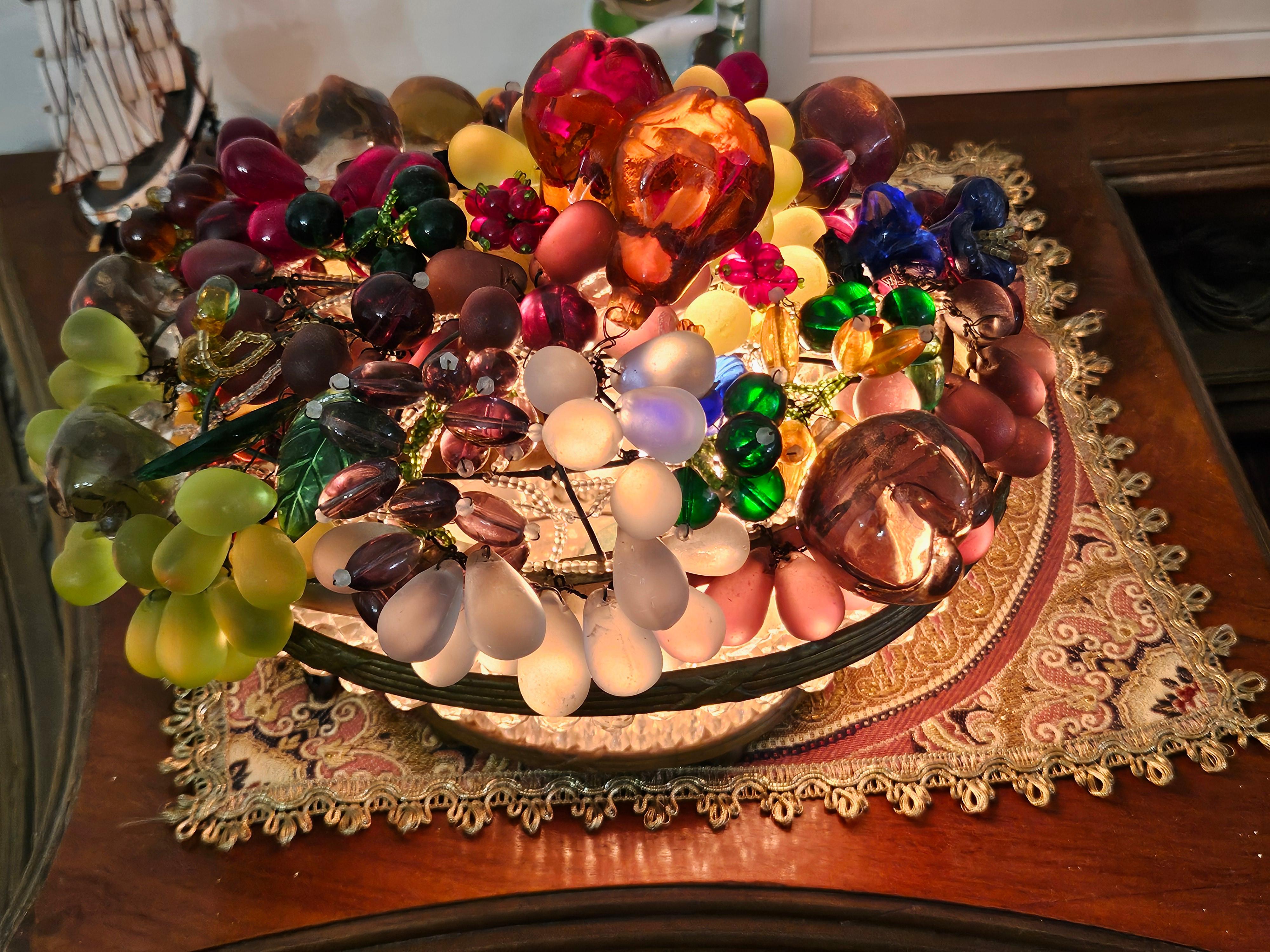 Magnifique lampe à fruits en verre perlé de Bohème tchécoslovaque, circa 1920. Panier orné en forme de cercueil ovale, avec des formes florales en relief à l'extérieur, et des fruits en verre colorés. Magnifiquement éclairé par une lampe intérieure