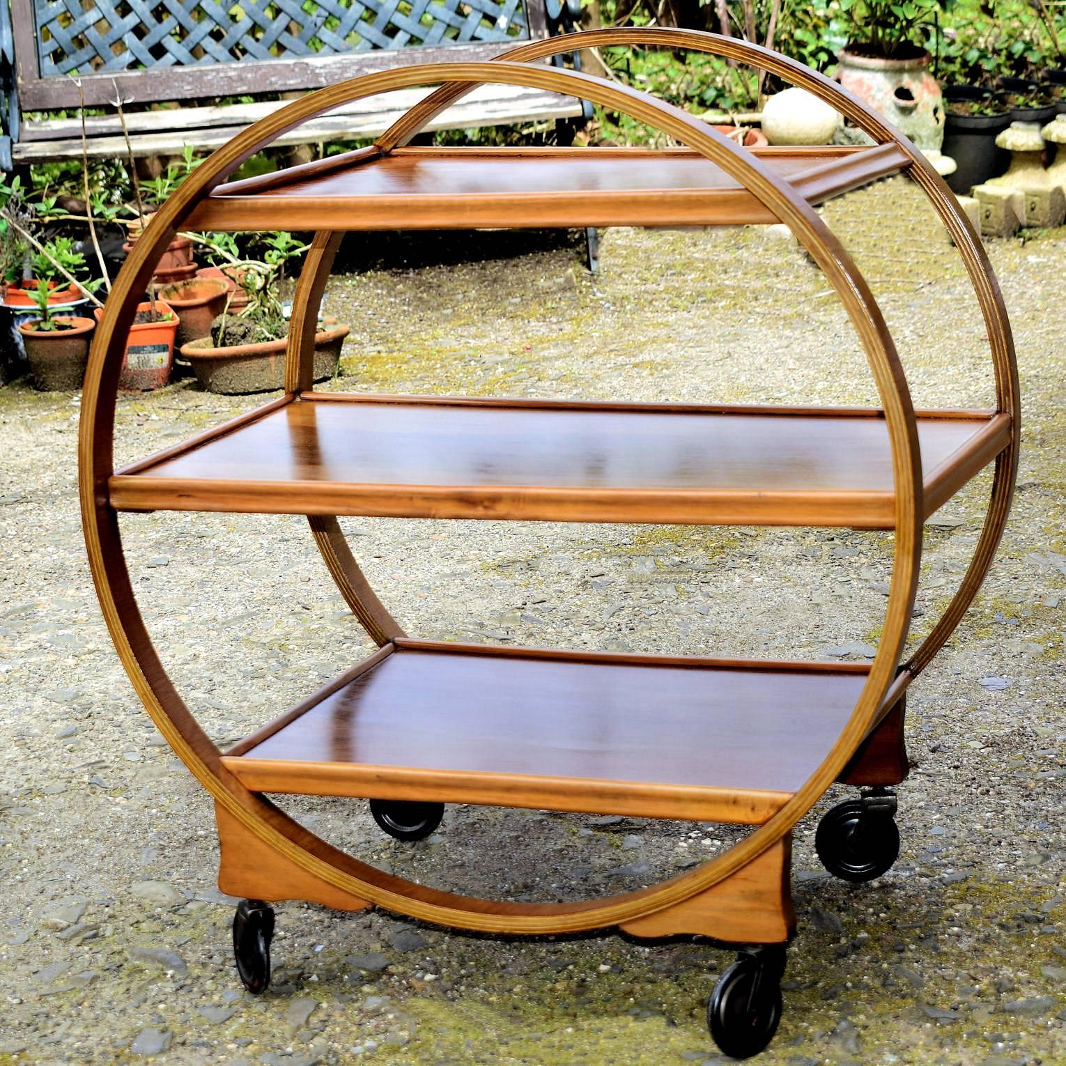 Very attractive and iconic English Art Deco Hostess trolley cart dating from the 1920s-1930s period. This three-tiered trolley not only looks awesome but is very functional too. Veneered in a mid-tone walnut with original fully functioning casters.
