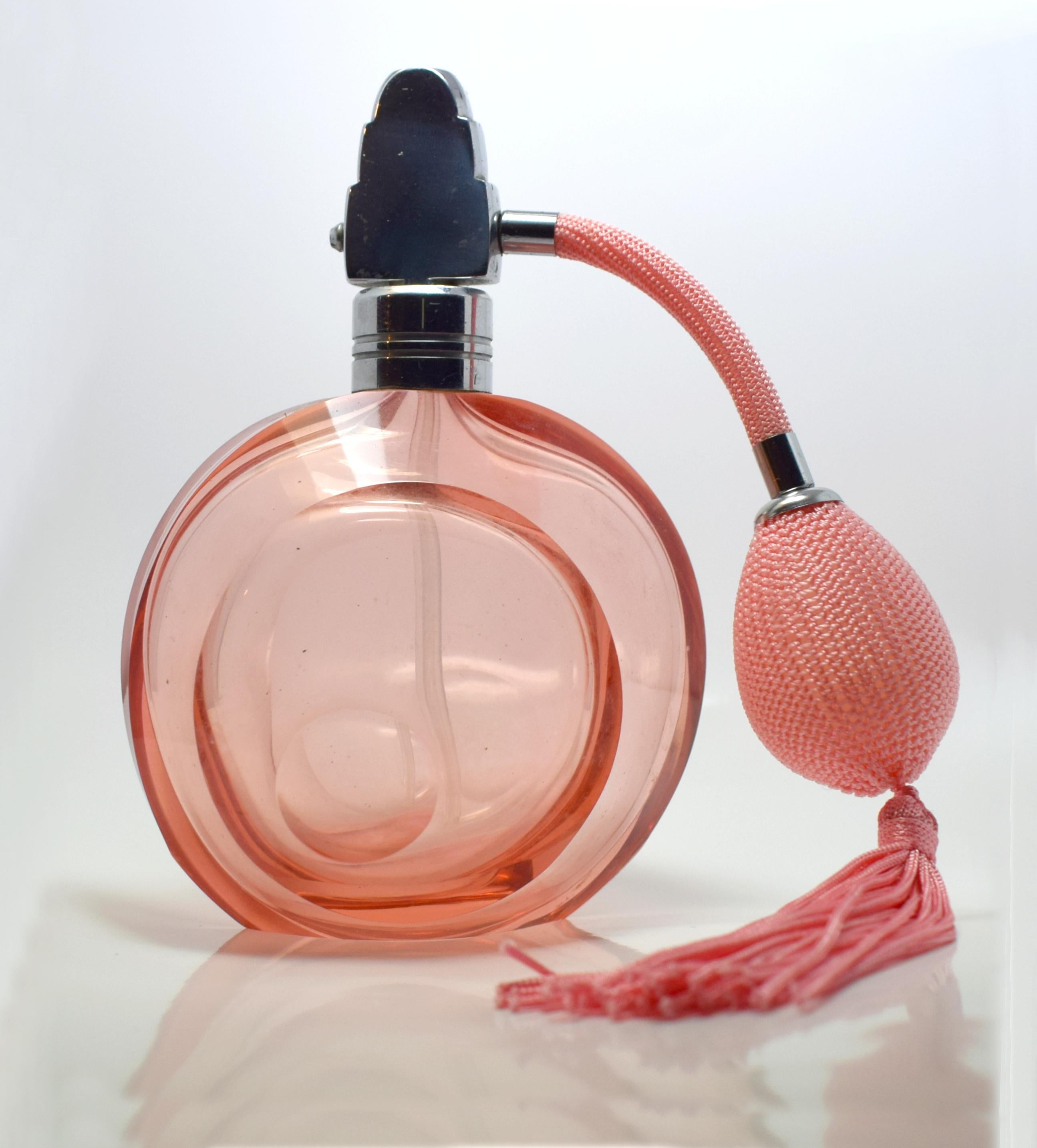 This large perfume atomiser is an absolute delight. 1930s authentic Art Deco with a very desirable overall design in peachy color. Glass is in excellent condition with no damage or flaws to report. The tassel and puffer are also in good condition