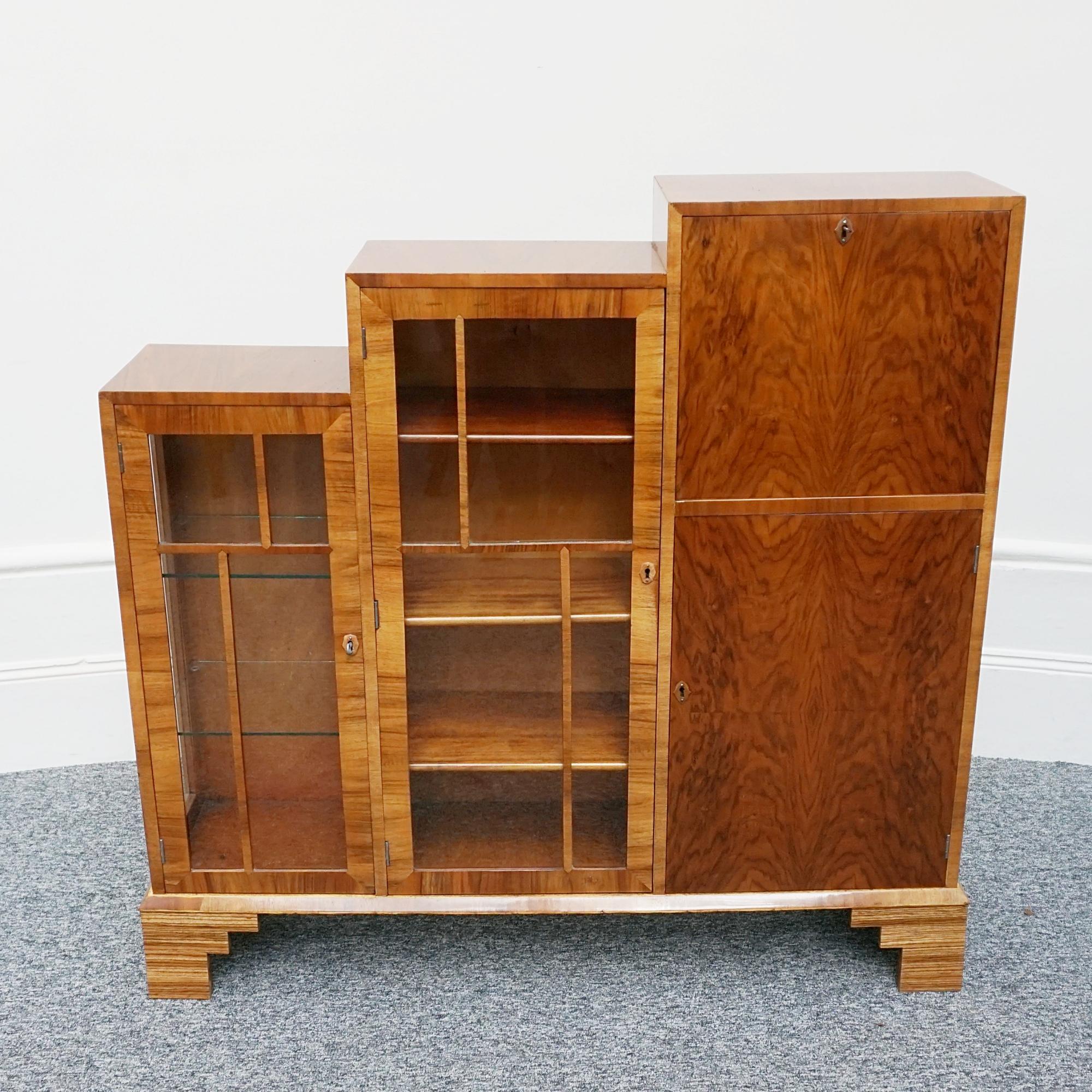 An Art Deco skyscraper bookcase/secretaire cabinet. Burr and figured walnut veneered. 

Dimensions: H 117cm W 121cm D 28cm

Origin: English

Date: Circa 1935

Item Number: 3010233

All of our furniture is extensively polished and restored where