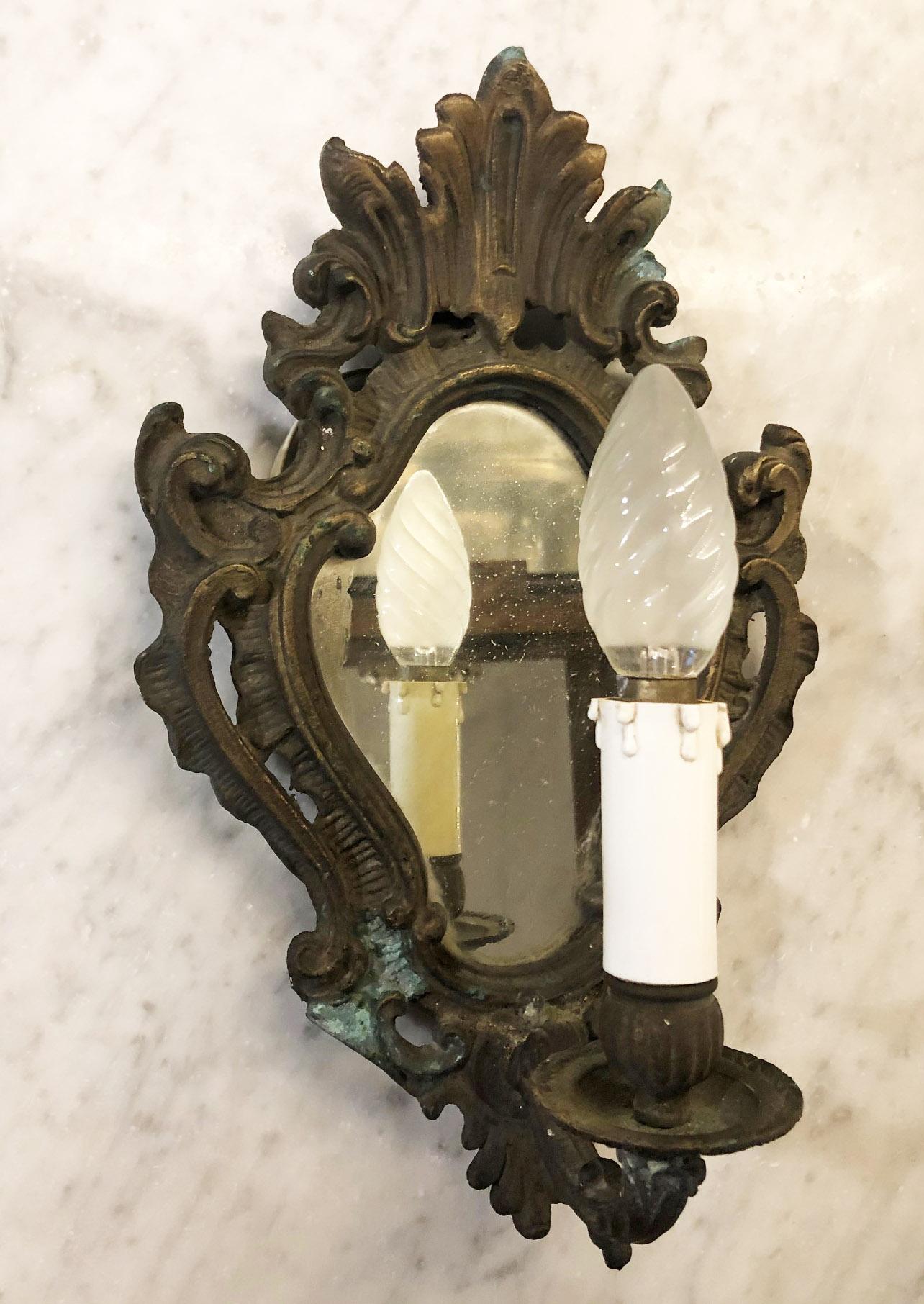 Original 1940s Italian bronze wall lamp with old mirror.
In working condition.
Equipped with original 20th century European wiring.
We recommend buyer consults an experienced electrician for proper installation.
The fixture requires one European E14