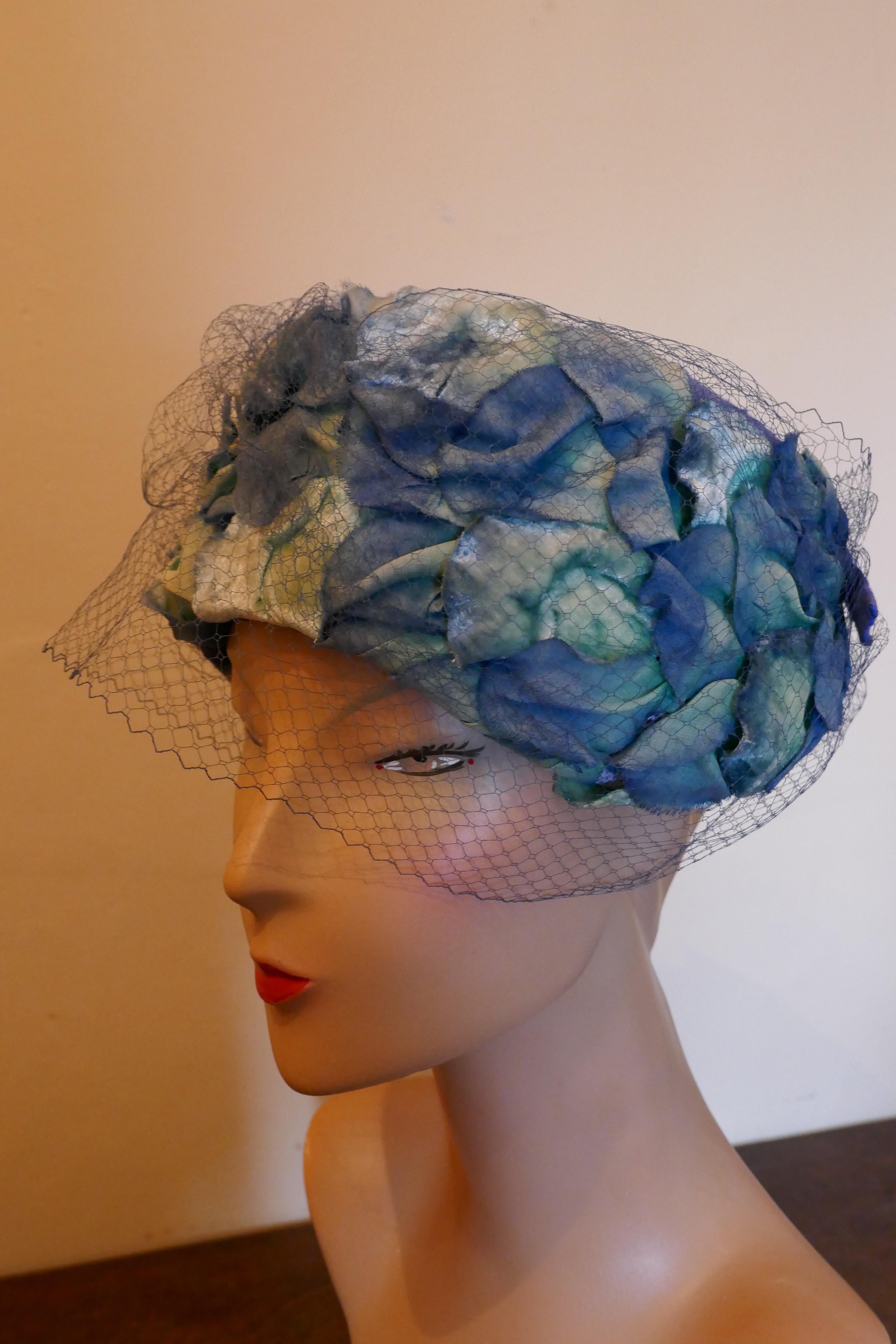Original 1950s Blue Pill Box Hat, Decorated with Roses and Veil, by Connor

Stunning classic pill box hat, in linen decorated with rose petals, trimmed with a small veil and designed by Connor
One for the Summer Garden Party
The Hat is in good