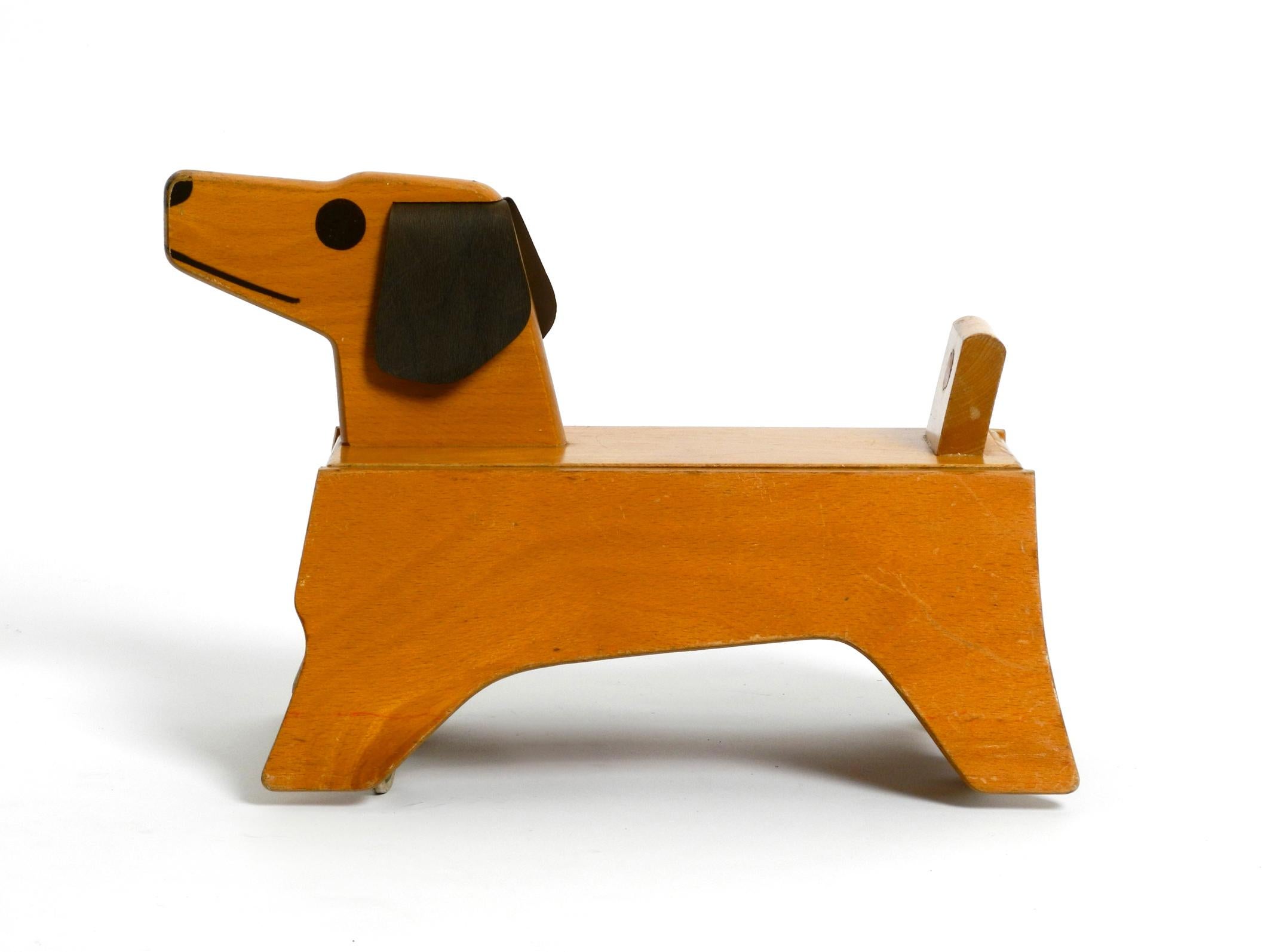 Rare original 1960s toddler sliding vehicle. A wooden dog made of plywood.
Made by Konrad Keller Holzspielzeuge, Göppingen.
Modern postwar design in original condition.
Very good condition with nice patina. All original parts complete. 
No