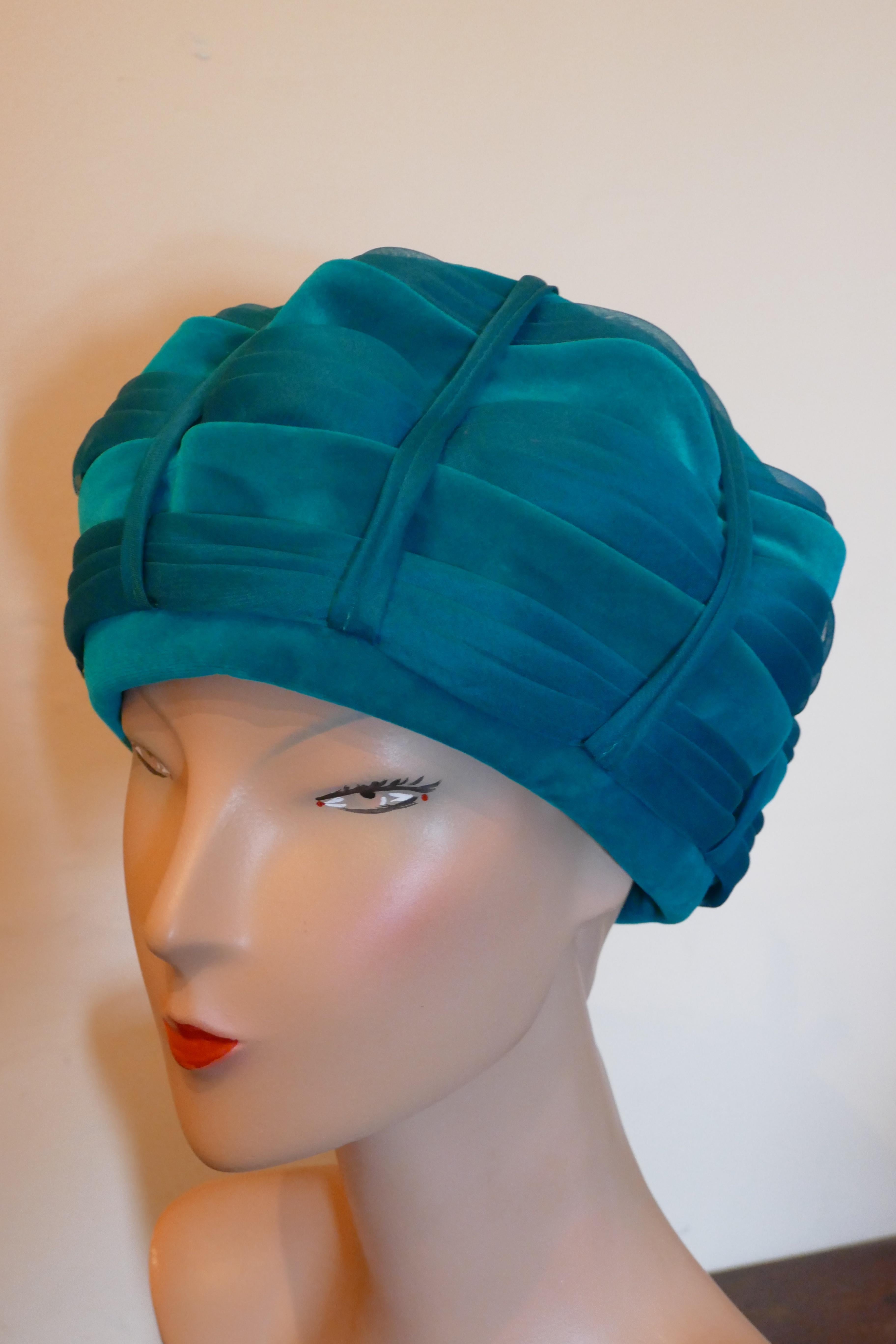 Original 1960s Beret Style Teal Pill Box Hat, Divided Beret

Stunning divided beret style pill box hat, the pleated velvet is divided into sections with chiffon and Satin ribbons,
The beret has a stylish shape and with a gathered ribbon decoration