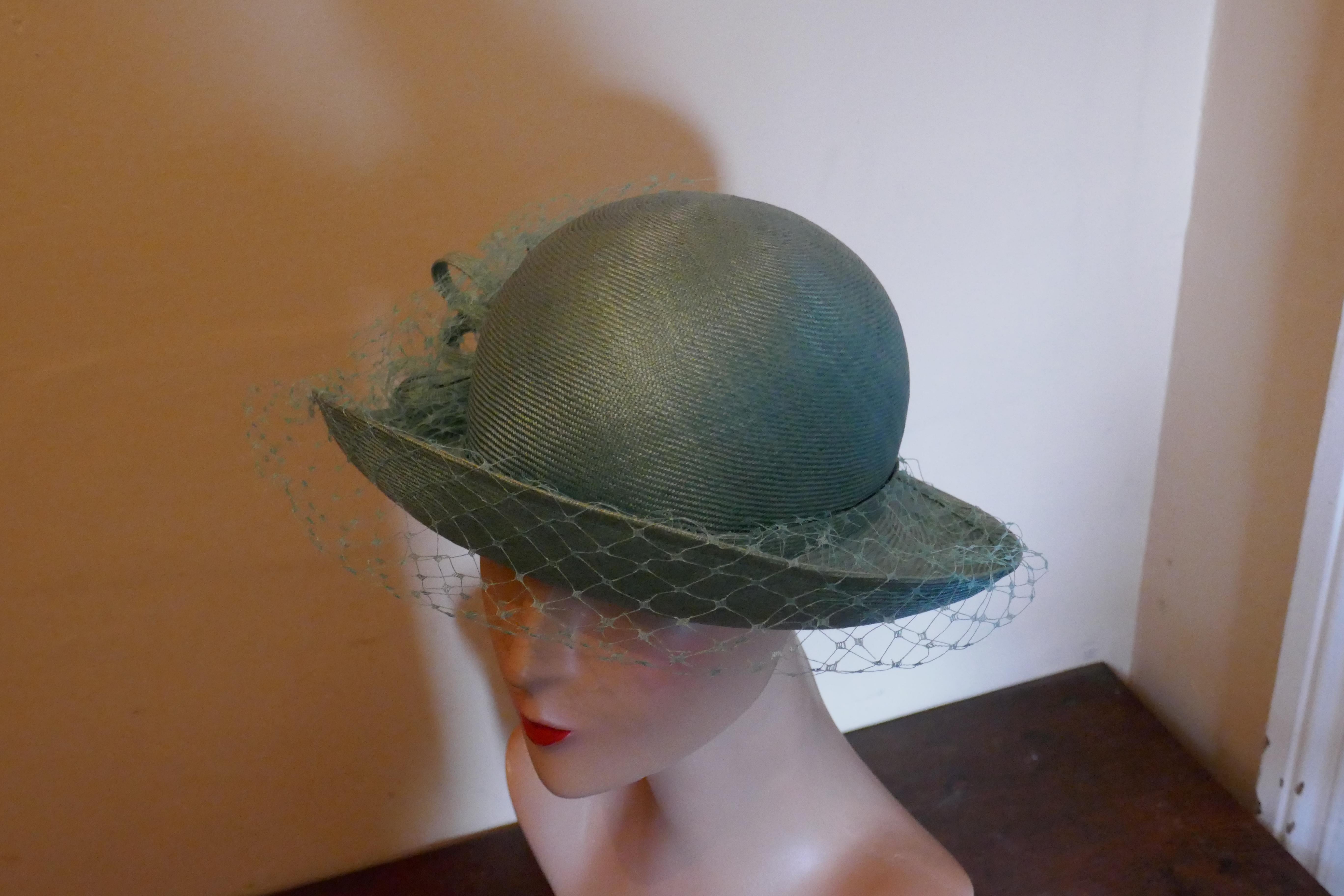 Original 1960s Duck Egg Green Veiled Shiny Panama Hat by Edna Wallace

This is a very elegant hat, it is made in soft shiny straw fabric with curled brim which is trimmed with a bow and crisp veil  
This one is a classic design, a timeless pice wear