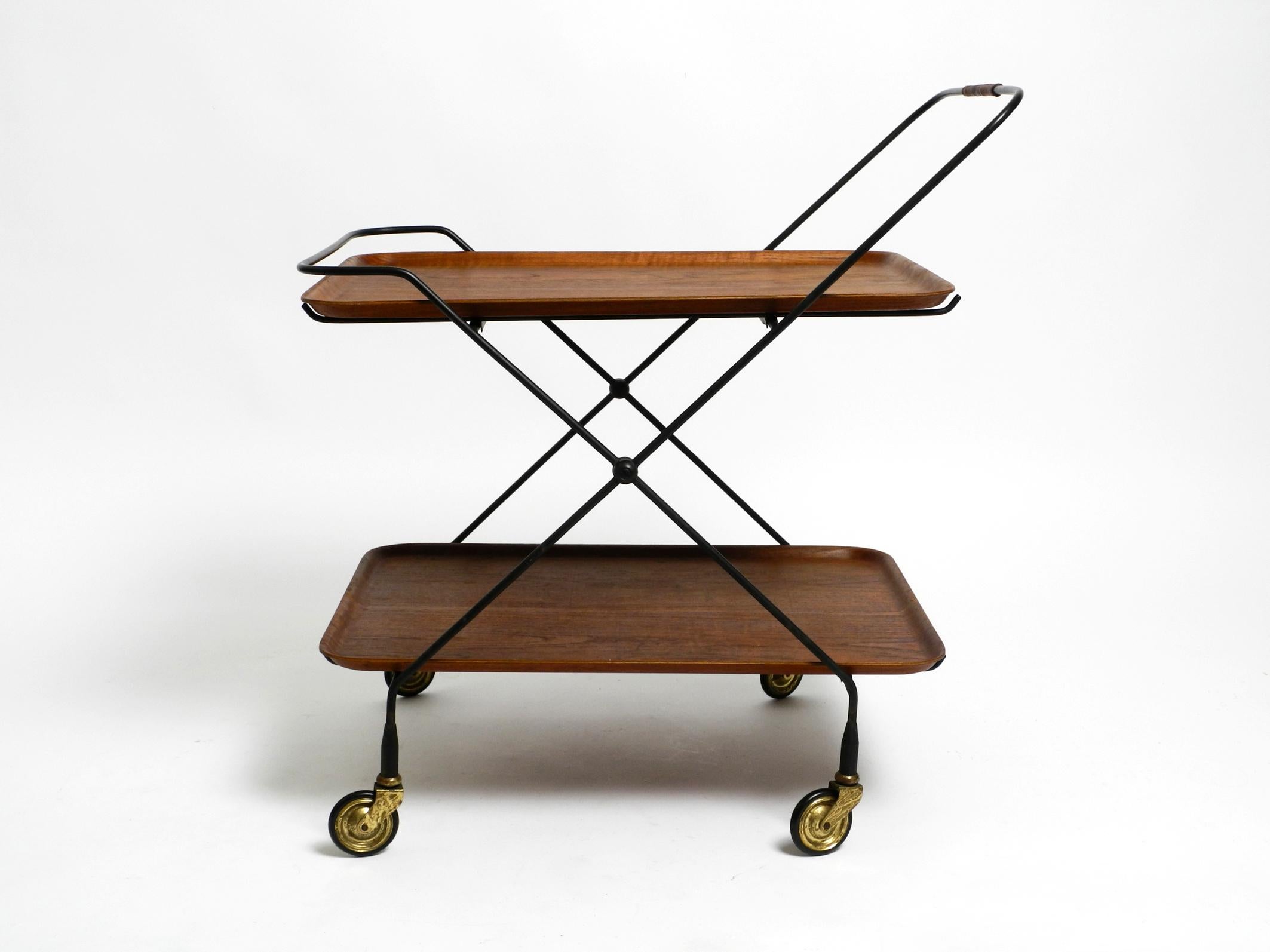 Beautiful original folding 1960s teak serving trolley or side table with wheels by Ary Fanérprodukter Nybro.
Made in Sweden. With original label on the bottom of one shelf. Shelves/ trays are removable.
Minimalist Scandinavian Mid Century