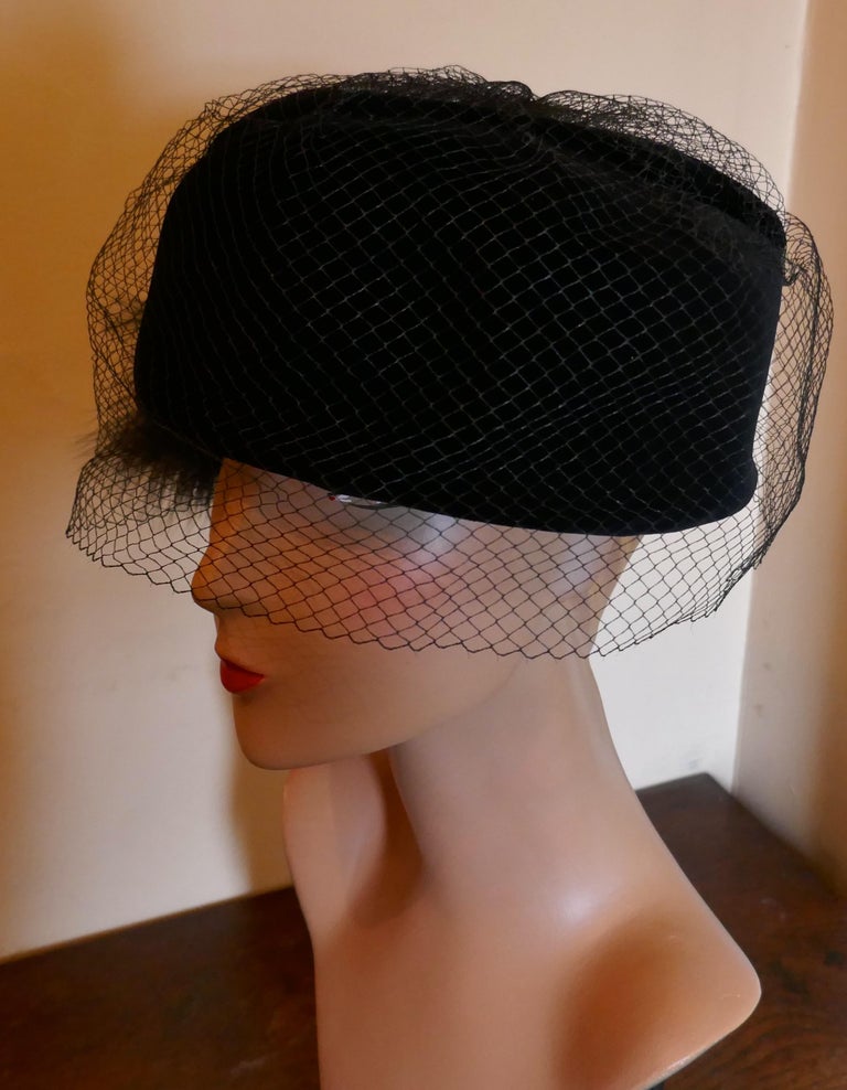 Original 1960s Vintage Black Pill Box Velvet & Feather Veiled Hat

Pill Box Hat made in soft 100% cotton velvet, trimmed with Ostrich feathers and veil for reclusion

The hat is very good quality and in very good condition, labeled Kangol Design and