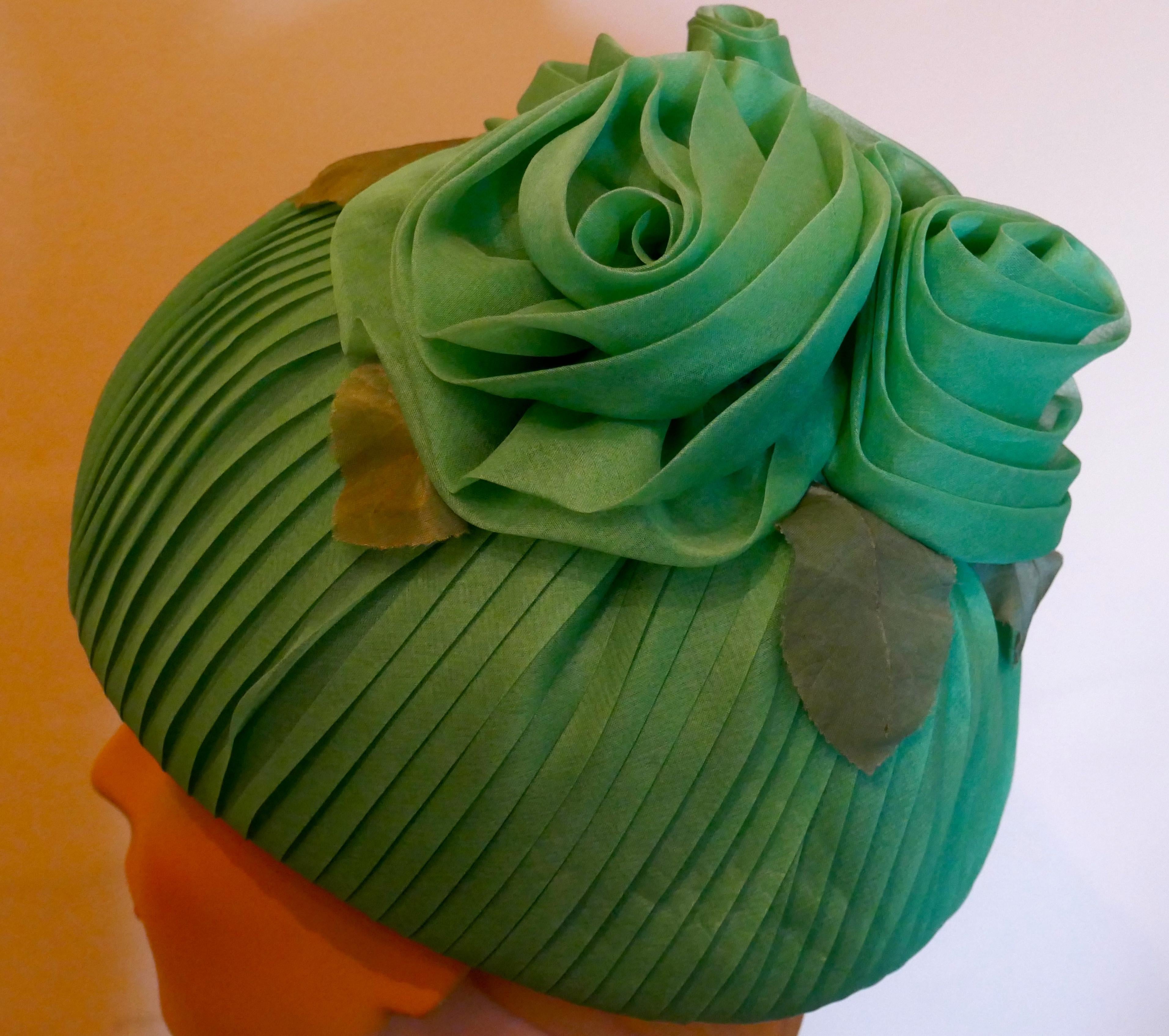 Original 1960s Vintage Gathered Chiffon Green Pill Box Hat

Formal hat for wedding or garden party, gathered chiffon decorated at the top gathered into flowers

Fun with style, this is a neat pill box with glamorous if not Royal look

The hat is