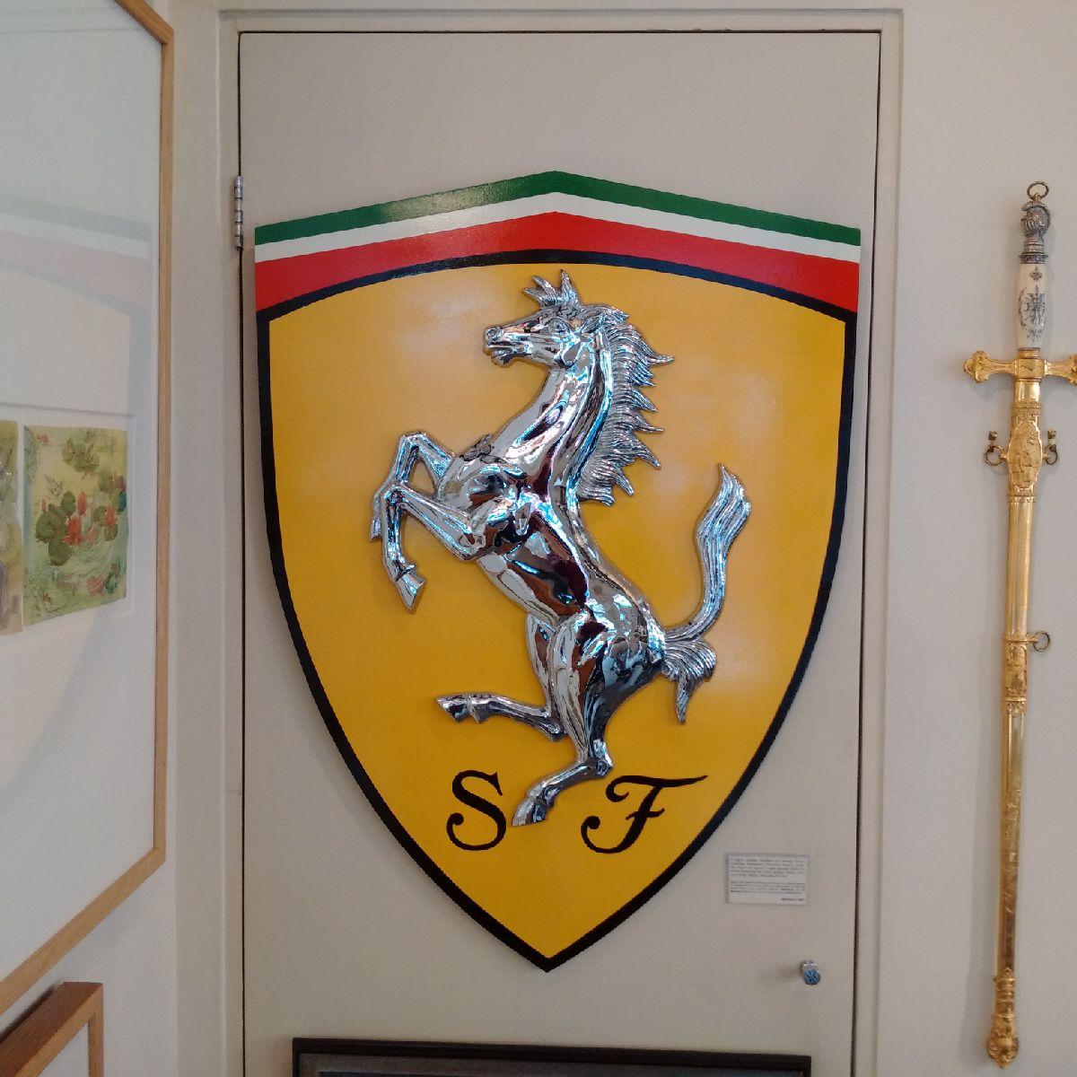 A highly unusual chromed cast bronze Ferrari Cavallino Rampante (‘Prancing Horse’) relief, the figure set against a hand painted Giallo Fly shield emulating the iconic symbol, and bearing the ‘S F’ initials of Scuderia Ferrari underneath. The relief