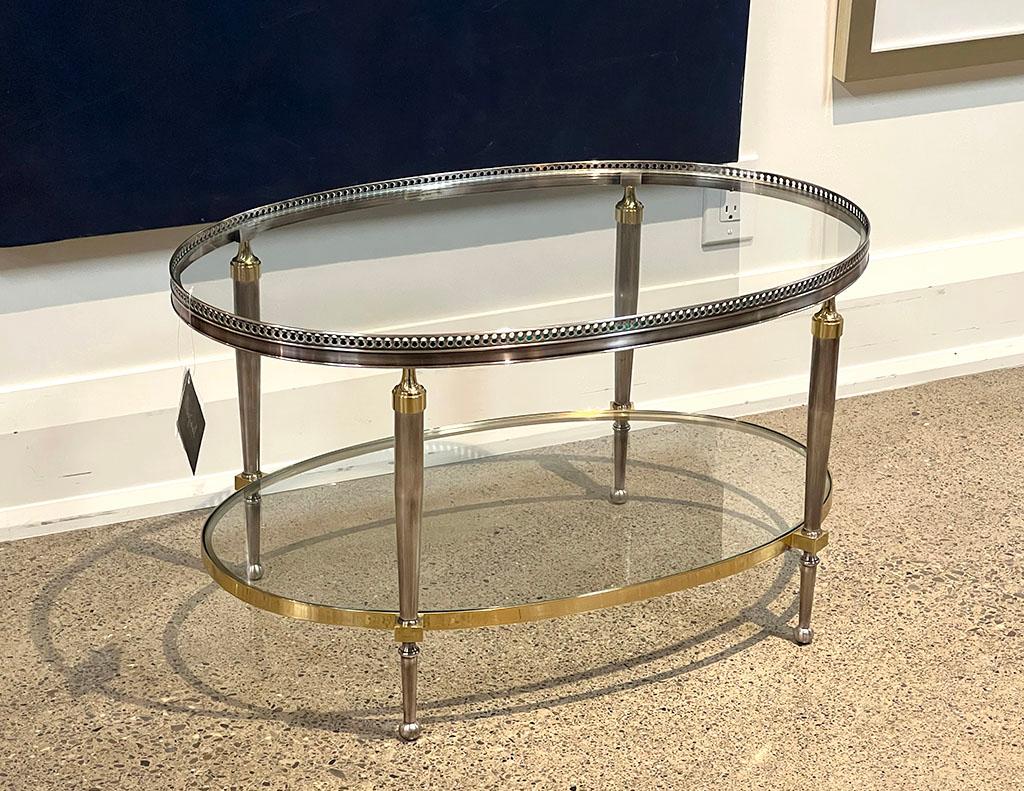 Original 1970’s Hollywood Regency oval accent table. 2 Tier design with unique metal detail on trim. Oval shape, glass tops, completed with brass accents and bottom ring. The perfect accent table for any living room space. Price includes