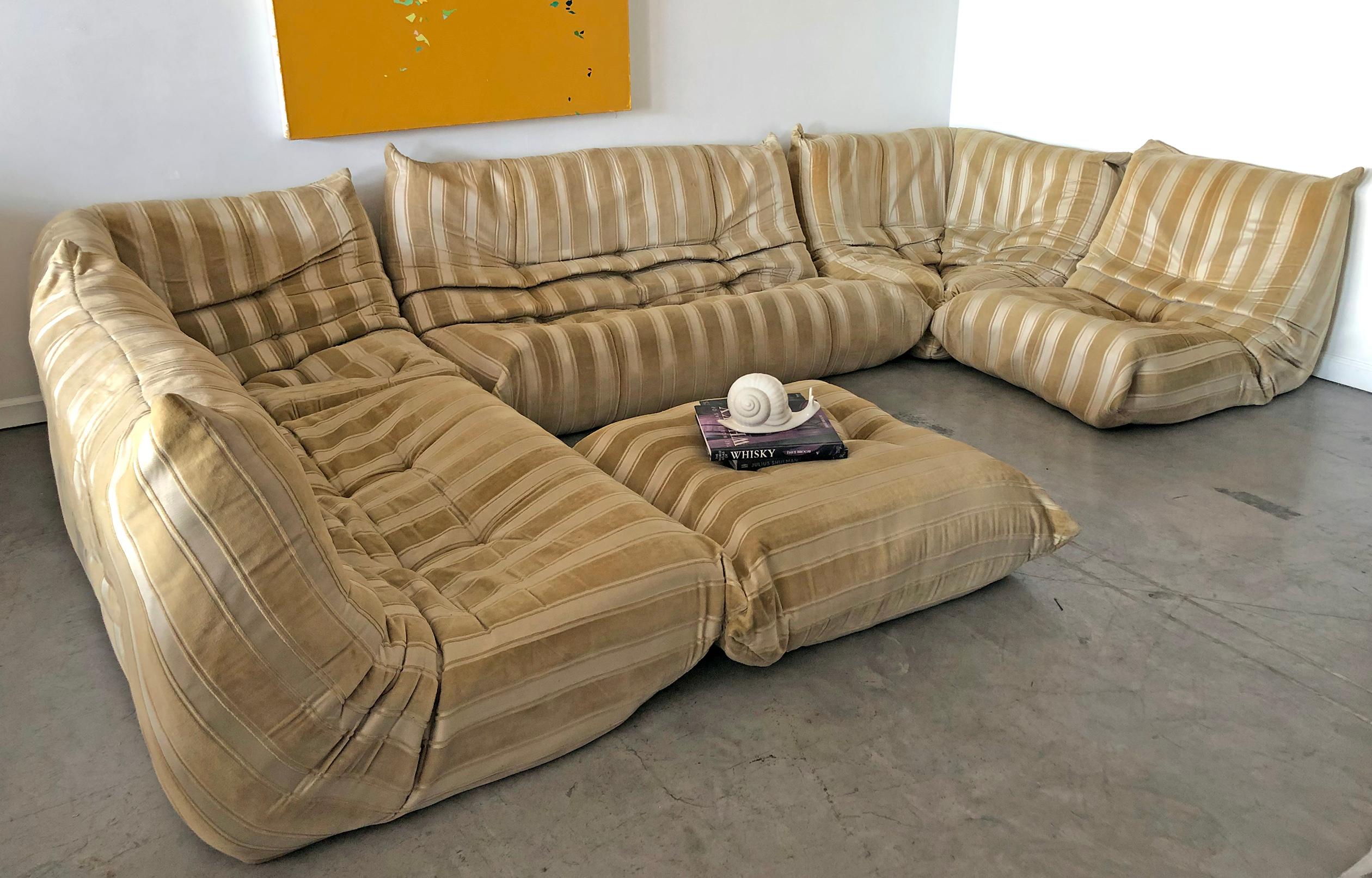 Available right now, we have an early original example of the modular sectional Togo sofa designed by Michael Ducaroy. This six-piece set is in good vintage condition with wear consistent with age and use. 
As configured: 147