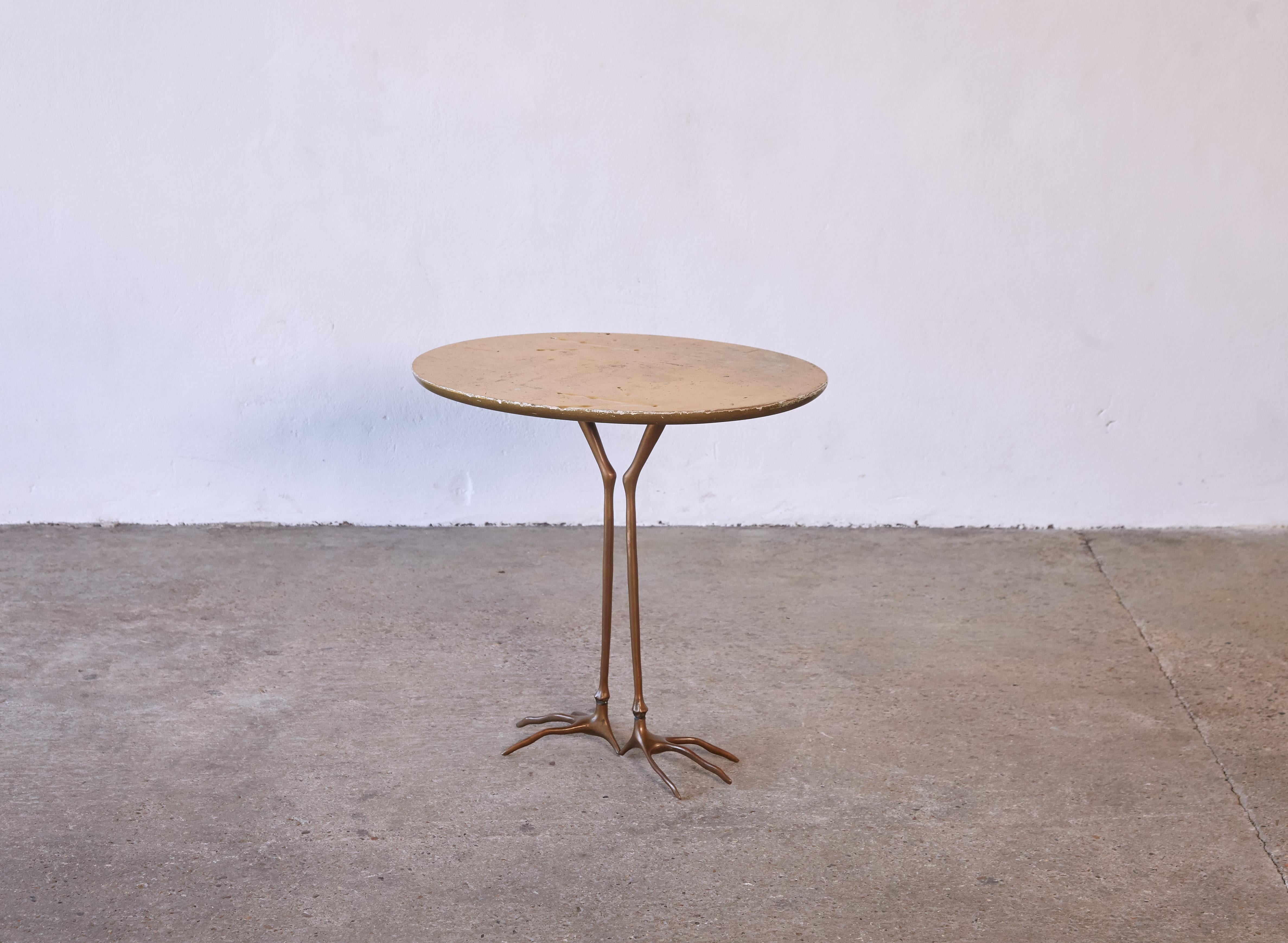 An original and authentic Meret Oppenheim Traccia table. This table manufactured by Gavina, Italy as part of the initial production in the 1970s. Oval shaped, original gold leaf top featuring bird footprints, on top of patinated cast bronze bird