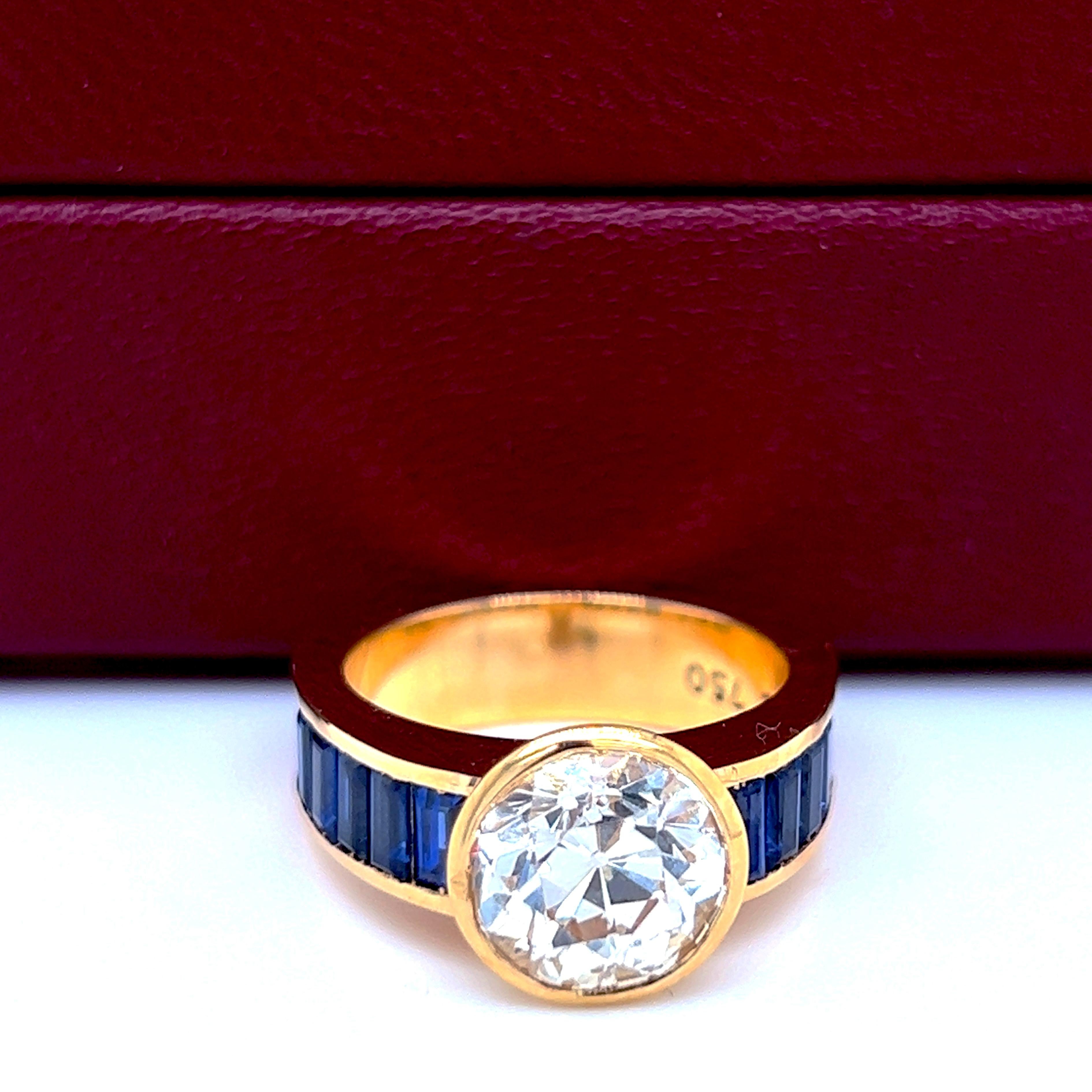 Unico nel suo genere, originale del 1980, sontuoso, unico e senza tempo, l'anello è caratterizzato da un diamante bianco taglio vecchio europeo da 3,29Kt in una montatura in oro giallo 18Kt taglio baguette accuratamente calibrata con zaffiri blu: