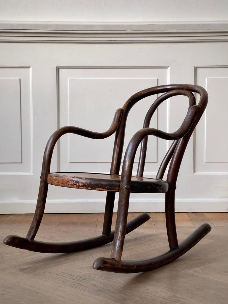 This rare late 19th-century bentwood children's rocking chair, crafted by Fischel in Czechoslovakia, is a delightful example of both craftsmanship and design innovation during the era. Retaining its original condition, the chair showcases the