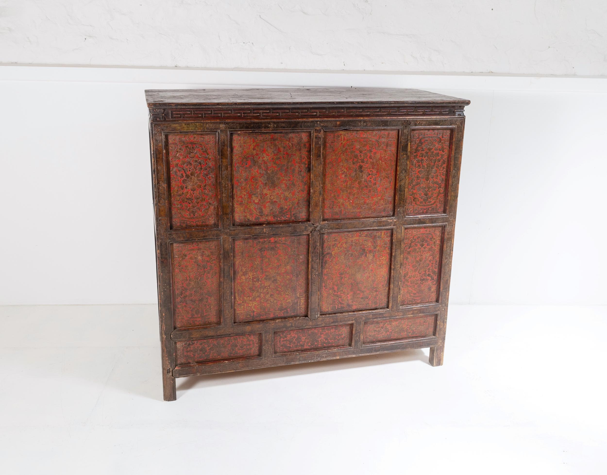 19th century Chinese Tibetan hand painted storage cupboard with original centre opening doors. A superb characterful piece in original lacquered paint with decorative floral tribal patterns. Hand carved detailing to the front.
A large deep cupboard