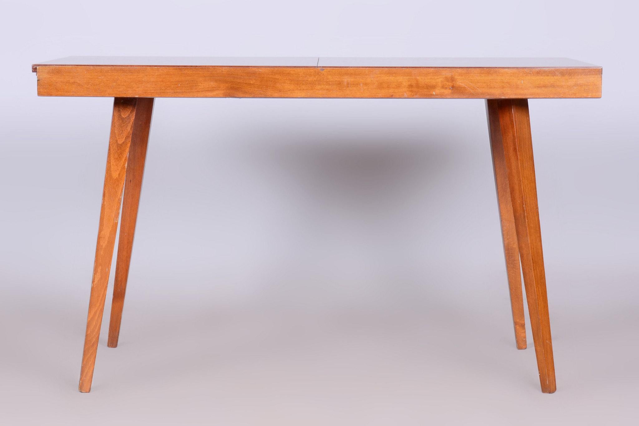 Cette table de salle à manger extensible du milieu du siècle dernier provient de Tchécoslovaquie et date du milieu du 20e siècle. Réalisé en hêtre et placage d'acajou, il est en très bon état d'origine.

La table est stable et entièrement