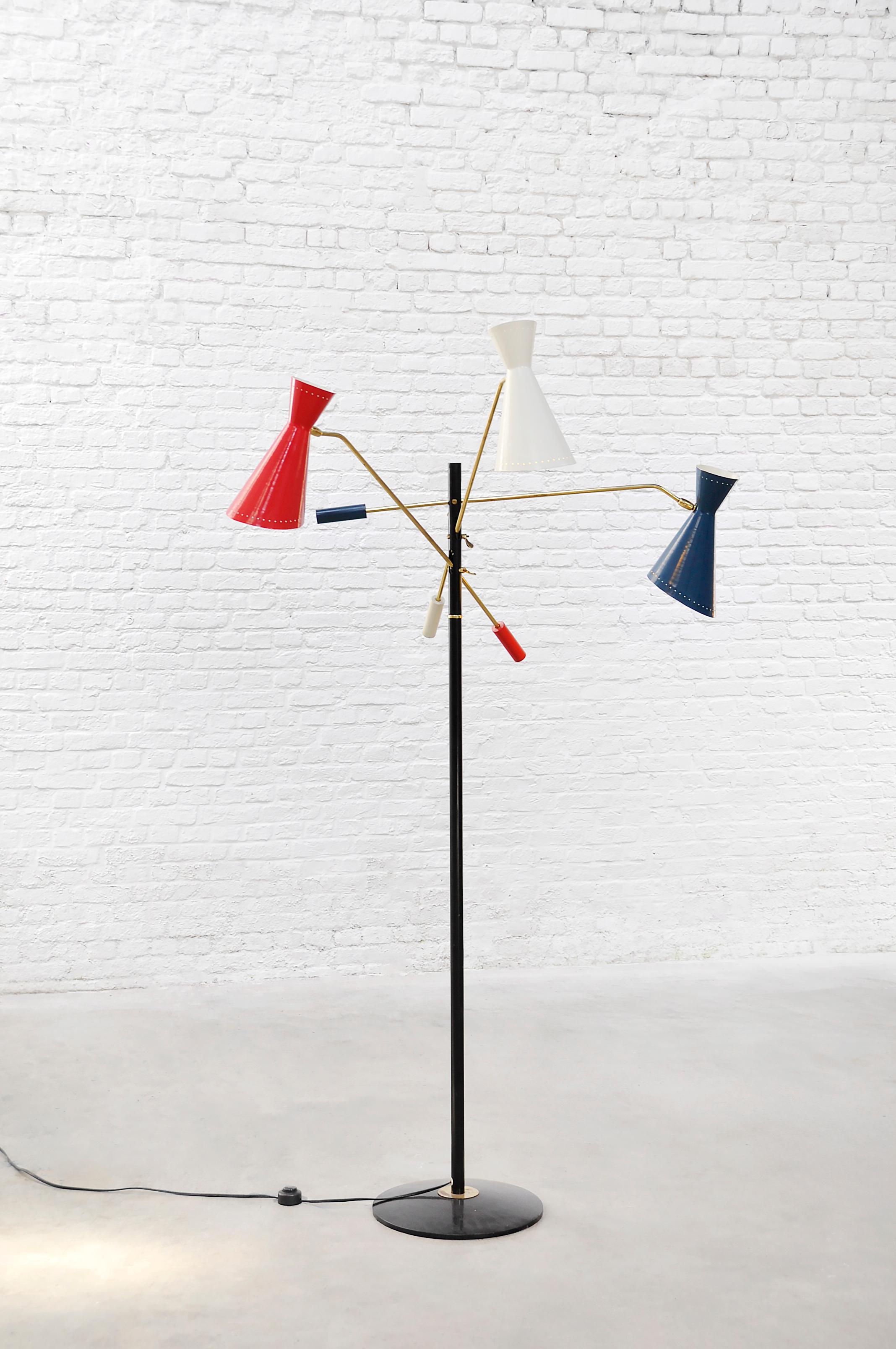 Original Italian 'Triennale' floor lamp attributed to Stilnovo, dating to the mid-1950s. Features a black-lacquered steel stem with three articulated brass arms, each ending in a double-cone (diabolo) shade finished in red, white, and blue lacquer.