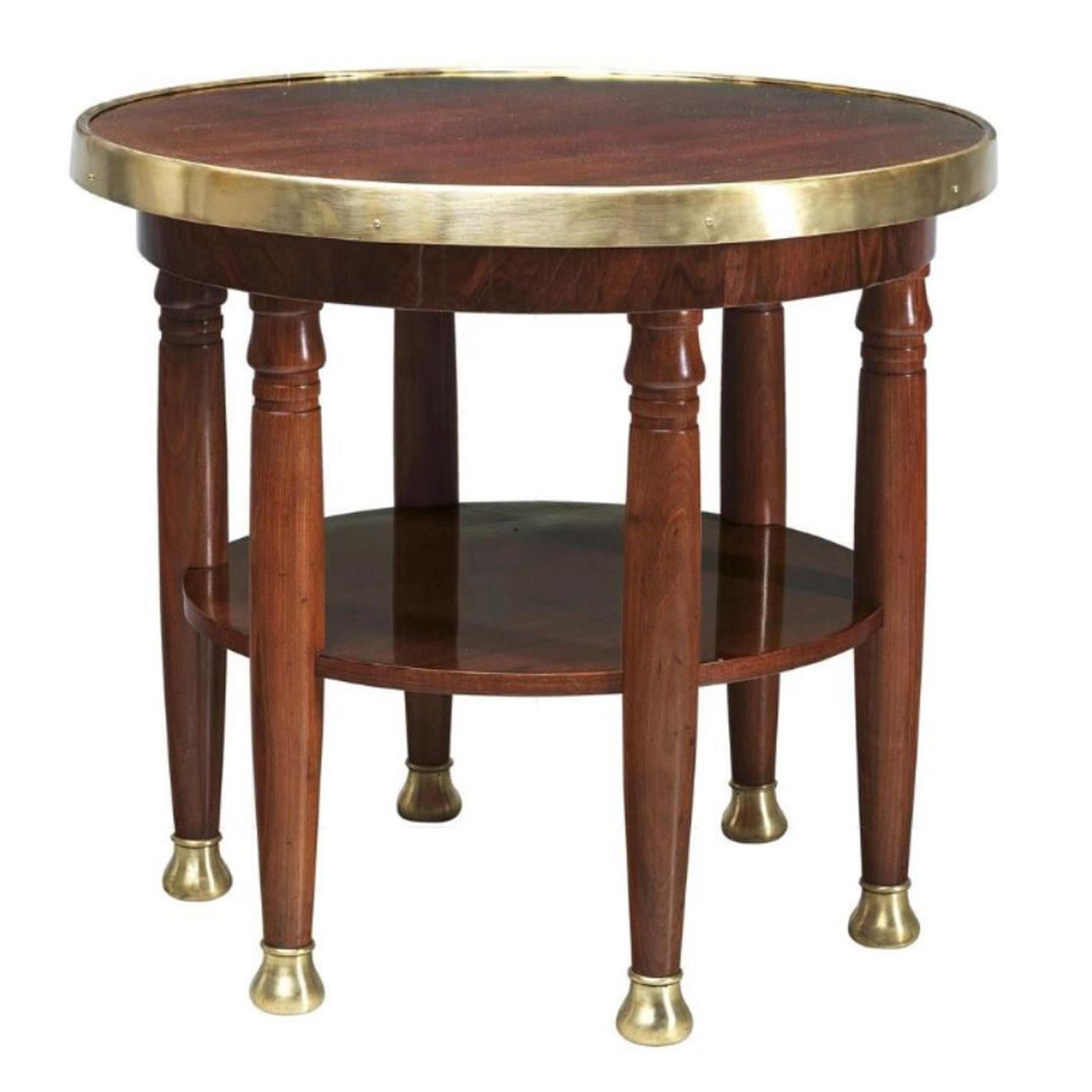Designed by Adolf Loos in circa 1902, turned hardwood and softwood frame on multiple legs, with walnut veneer and polished finish, brass edged top and brass sabots, height c. 74 cm, diameter c. 80 cm, in restored condition. Adolf Loos first used a