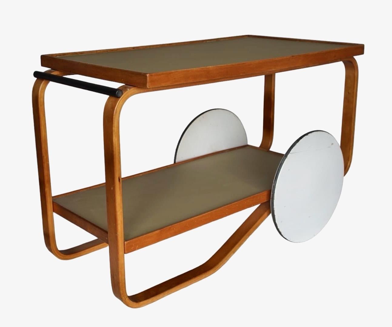 Alvar Aalto, un chariot à thé moderniste original en bouleau des années 1930, modèle 98, fabriqué par Oy Huonekalu-ja Rakennustyötehdas Ab pour Artek et distribué par Finmar ltd. 
Label Finmar en ivoire et numérotation imprimée présents - inserts