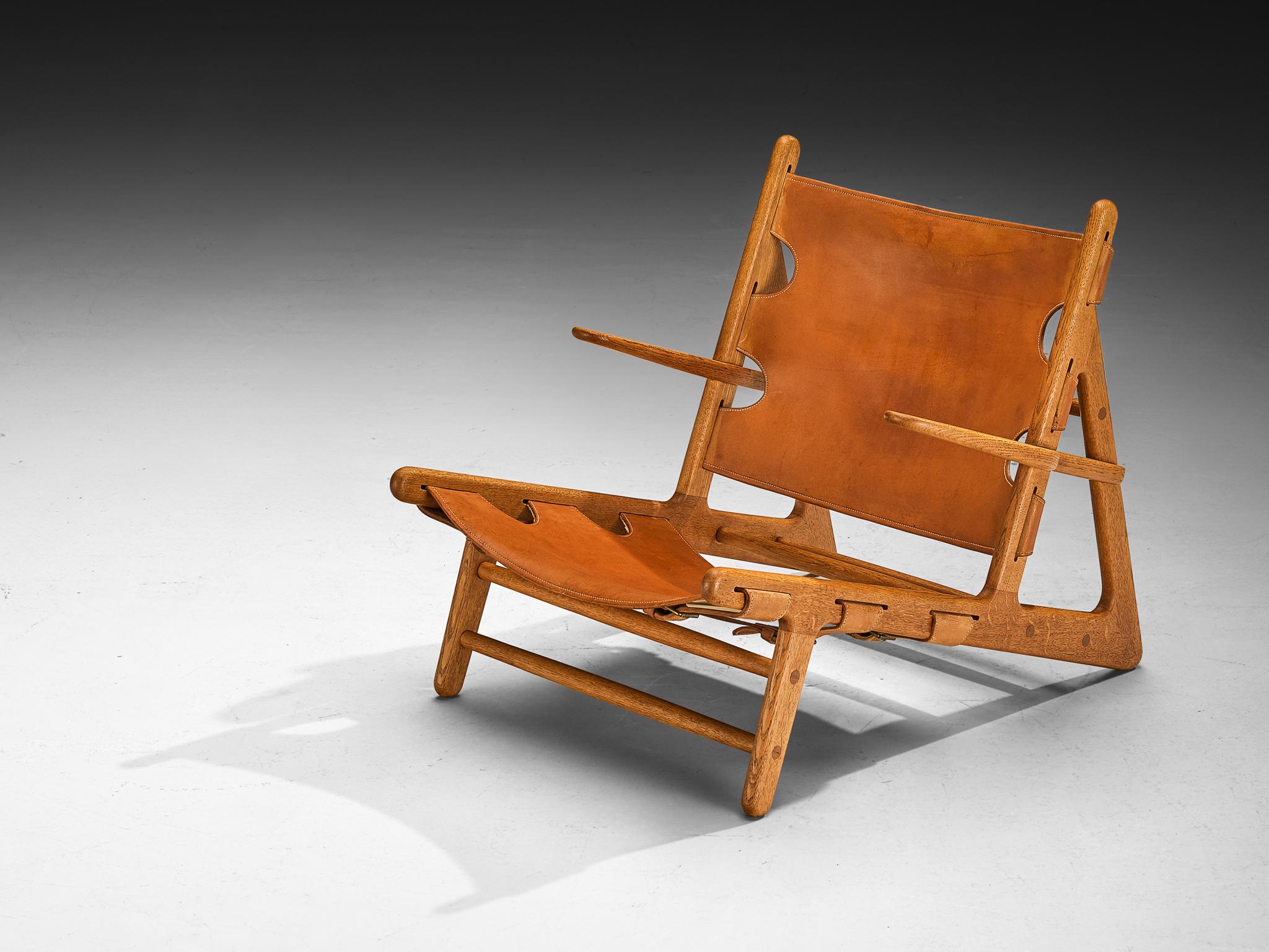 Børge Mogensen pour Erhard Rasmussen, original et rare 'Hunting Chair', cuir cognac, chêne massif, laiton, Danemark, design 1950 

Lors de l'exposition de la Guild de Copenhague en 1950, l'ébéniste Erhard Rasmussen a présenté un intérieur de