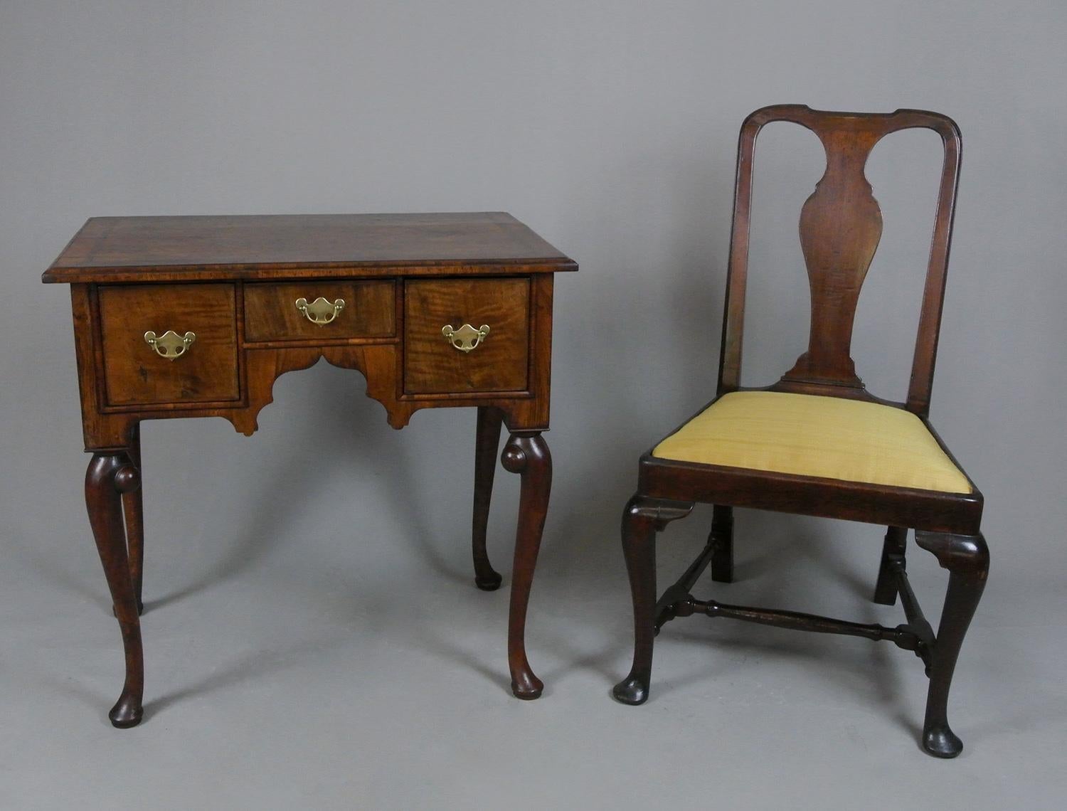 A very good George II lowboy with fabulously shaped solid walnut cabriole legs each with large hand carved and reeded scrolls at hips over rolled pad feet. The three drawers retain their original and very slim boarded oak linings with beautifully