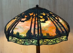 LÁMPARA DE PISO ORIGINAL DE BRONCE ANTIGUO CON VIDRIOS DE COLORES DE HANDEL: PUESTA DE SOL SOBRE PINOS
