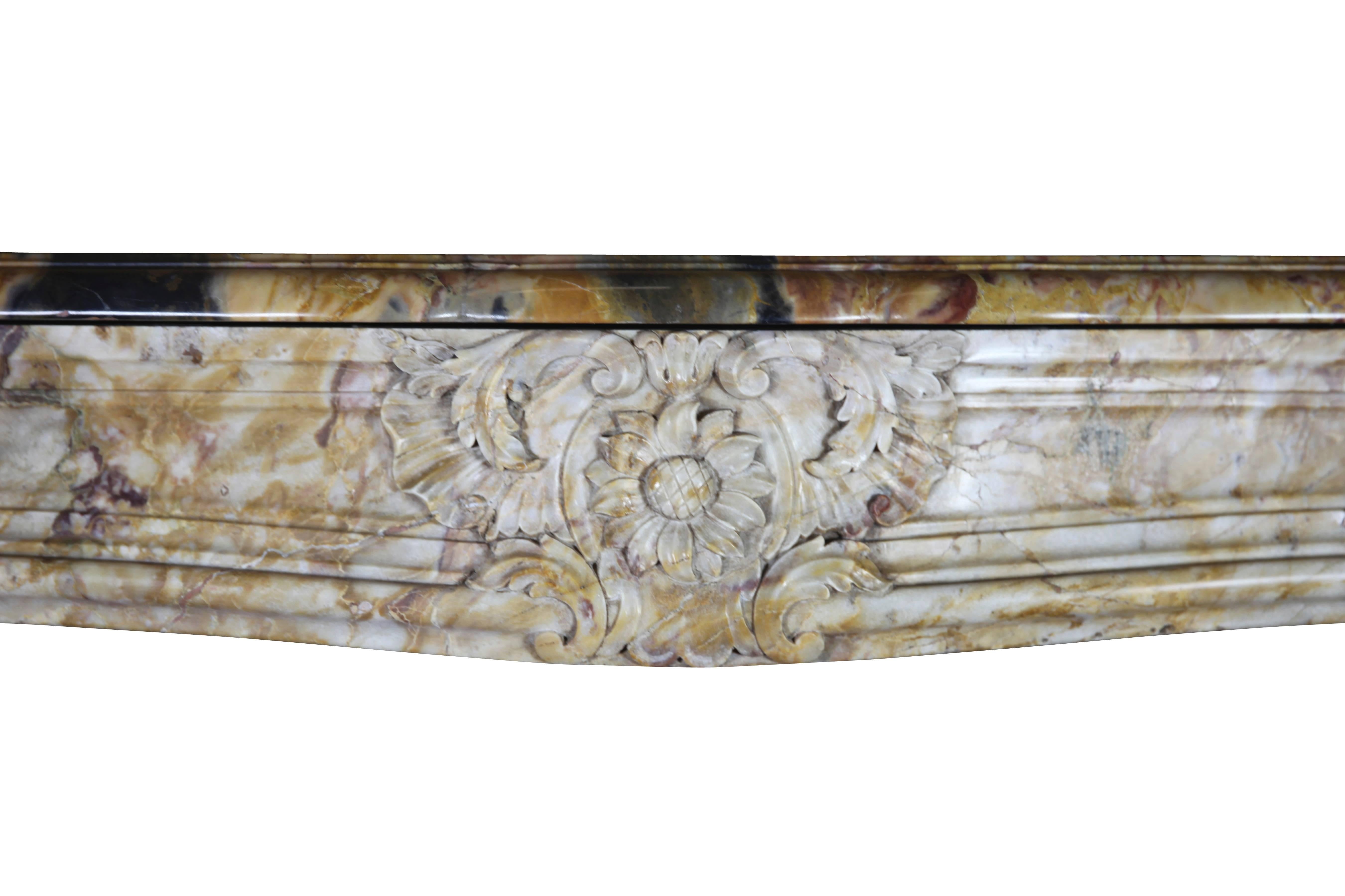 This colorful antique fireplace chimney piece is executed in a Royal French Brêche Vendôme marble. The carving details are fine and of a high quality. It reflects the luxury lifestyle of the interior it was built in. Original 18th century