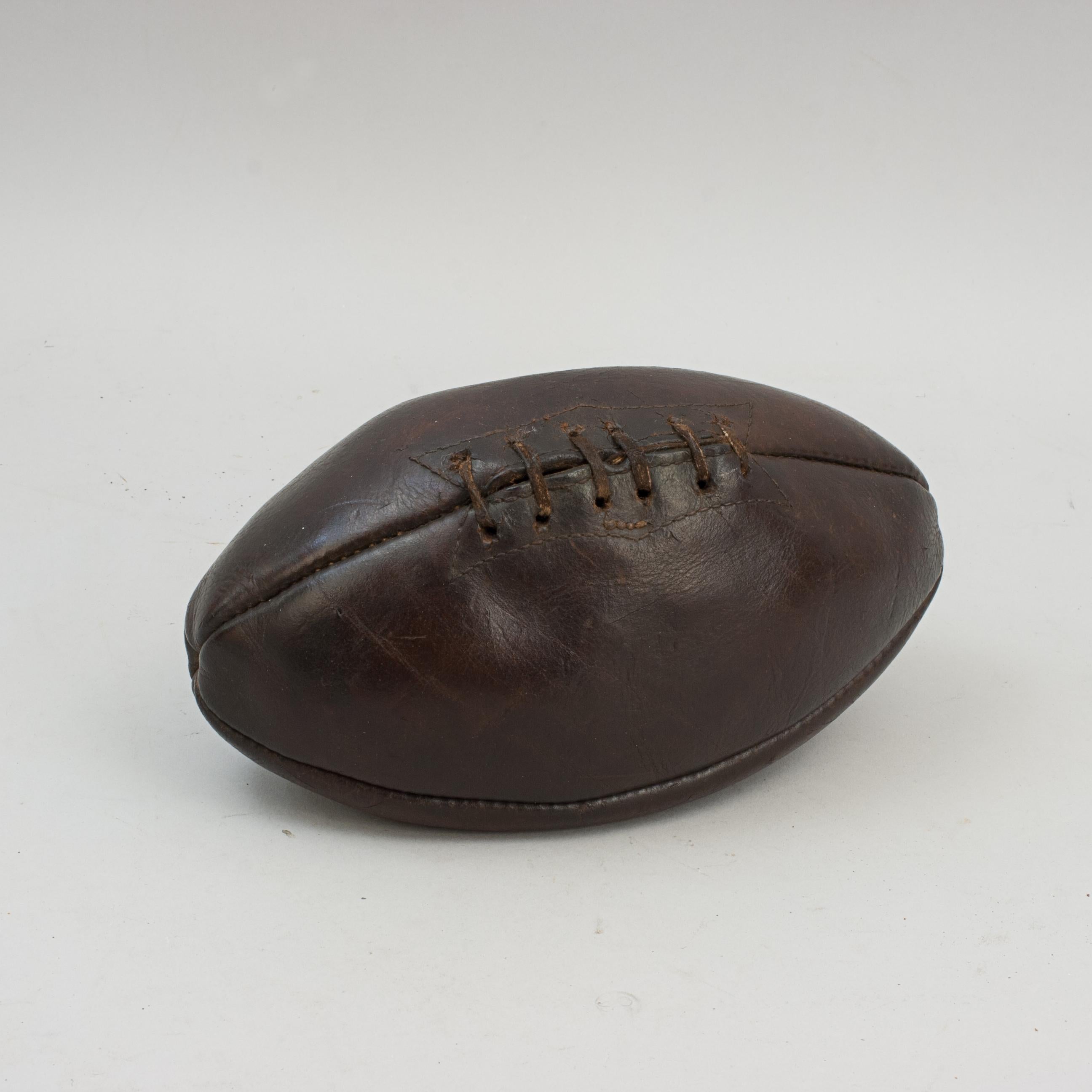 Original Antique Leather Rugby Ball.
A beautiful leather rugby ball made with the traditional four panels. It has had a lot of use and shows its age well, with good dark colour and patina. The ball has a lace-up slit to the front that would have