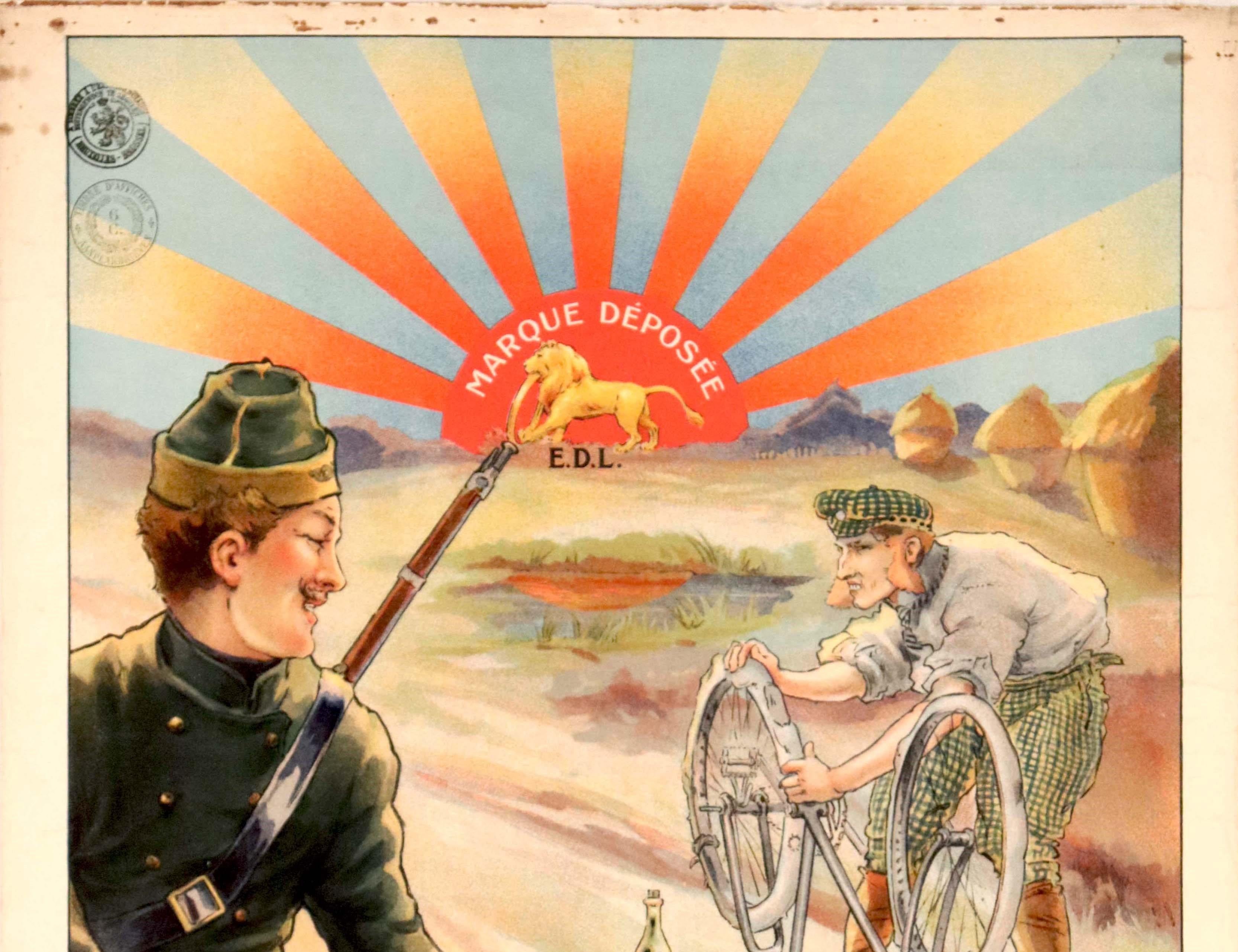 Affiche publicitaire ancienne originale pour les pneus Le Lion présentant une illustration d'un soldat carabinier belge souriant, fusil à l'épaule, passant à bicyclette devant un homme réparant un pneu crevé sur son vélo au bord d'un chemin de