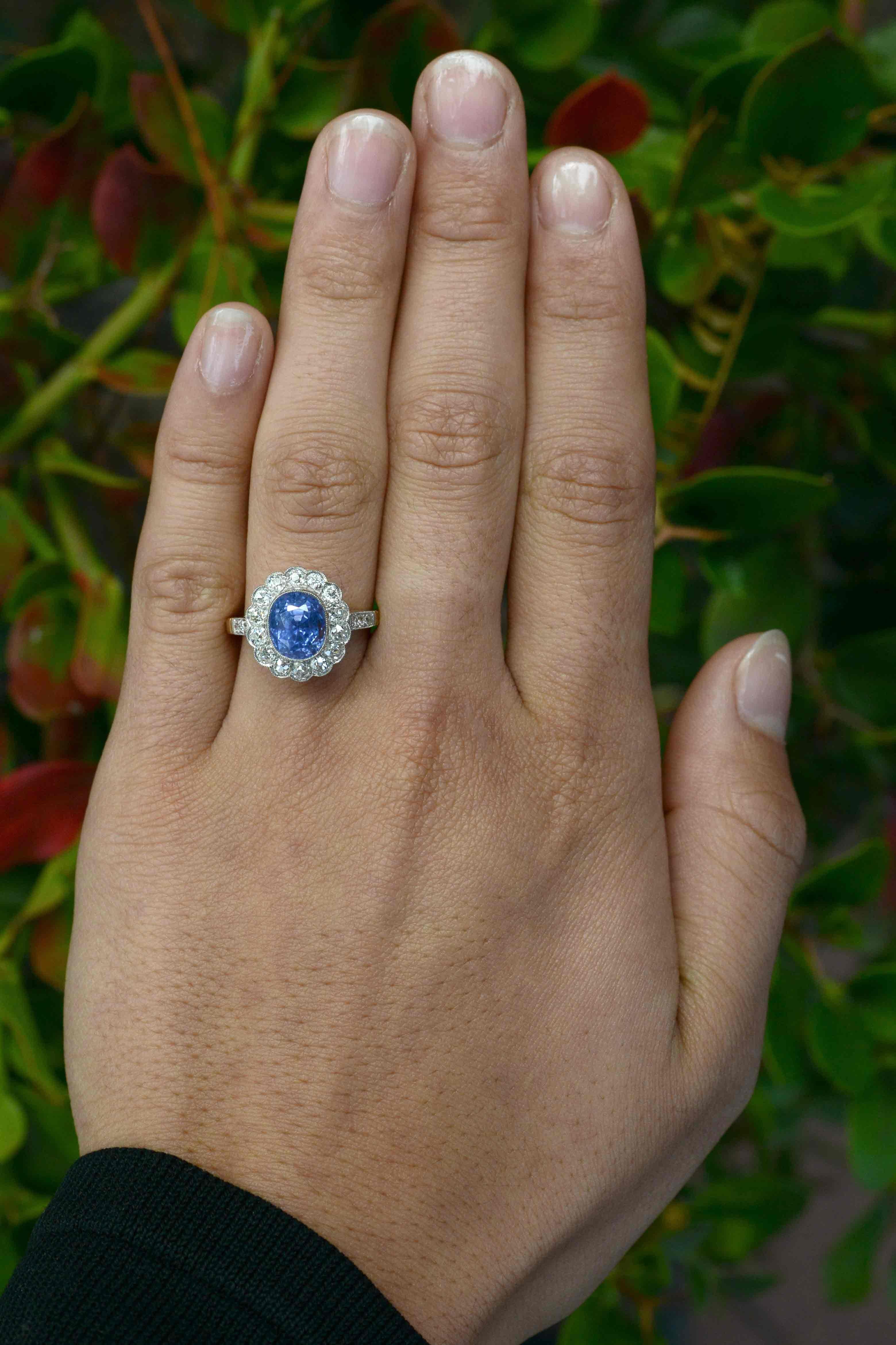Centering on an unusual, 4.30 Ct natural unheated sapphire of a most captivating violet blue, this original Edwardian antique sapphire engagement ring is an authentic heirloom, over 100 years old. The floral design cocktail ring adorned with 1 carat
