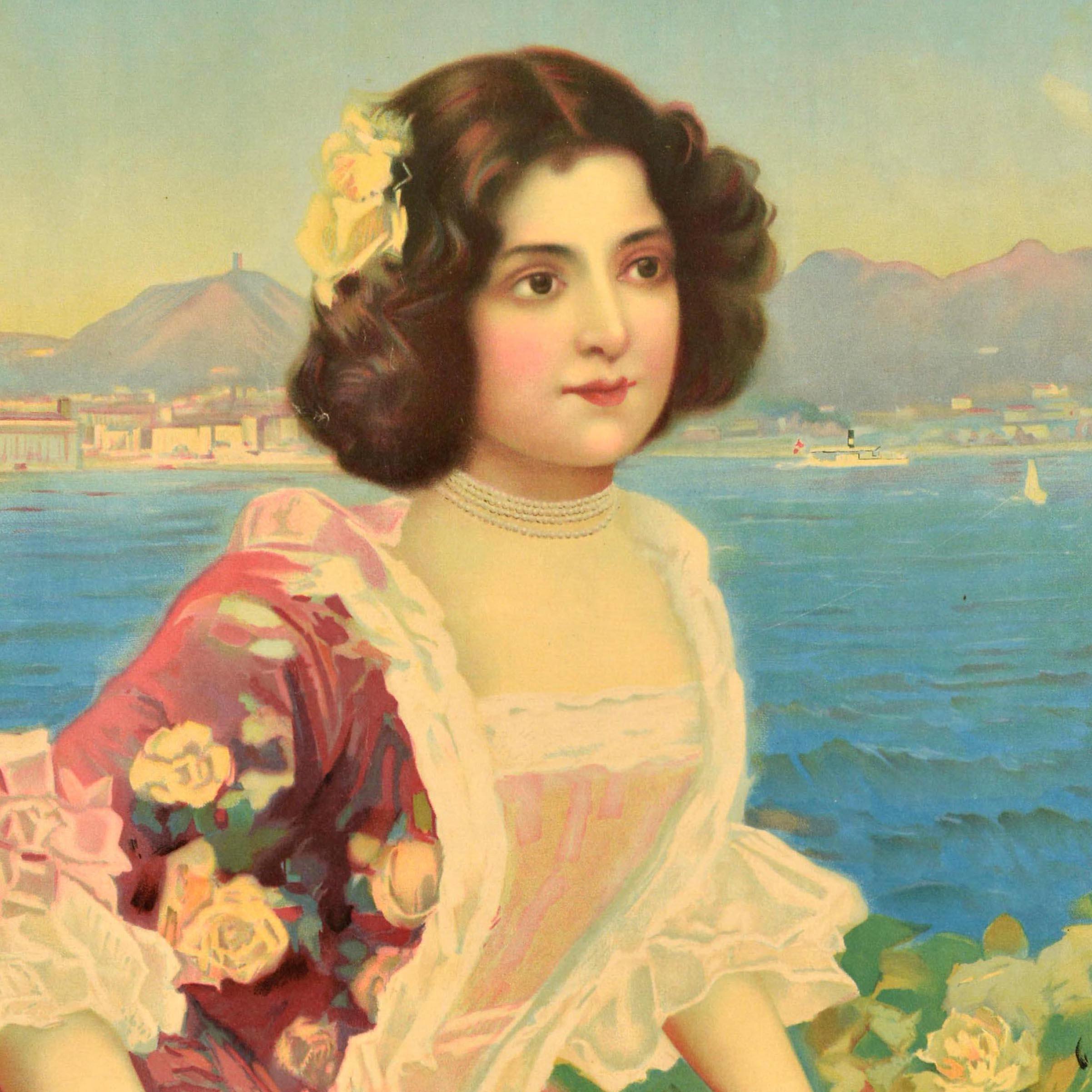 Original antique travel poster for Lago di Como featuring elegant Belle Epoque artwork depicting a lady in a floral pink rose dress with a flower in her hair standing at a decorative railing in front of sailing boats and steamers on Lake Como with