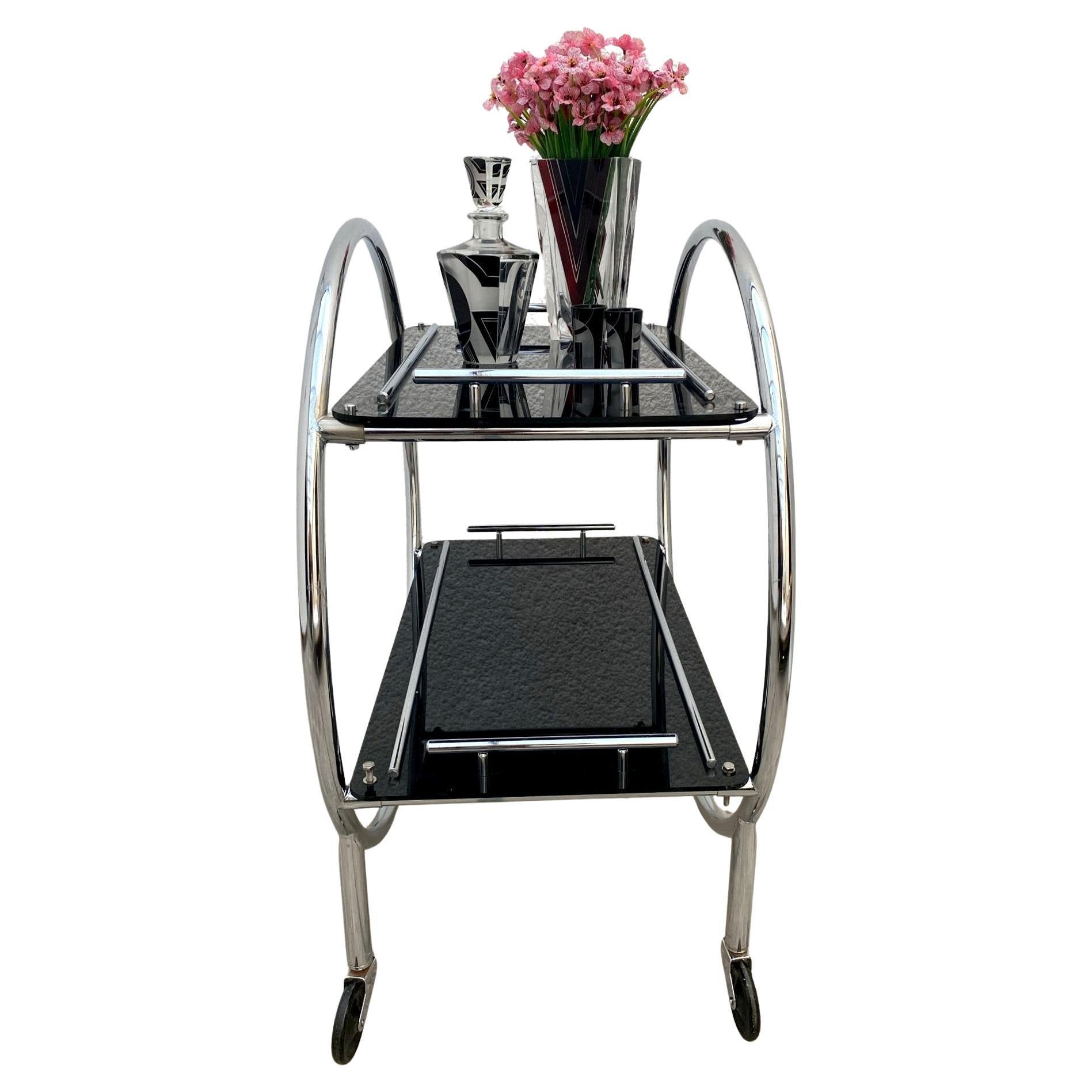 Now this really is a fabulous hostess bar cart. Original 1930s Art Deco chrome two-tier trolley. A tubular chromed frame makes up the skeletal body of the cart with thick acrylic inserts which are jet black with chrome bar accents, very glamorous!