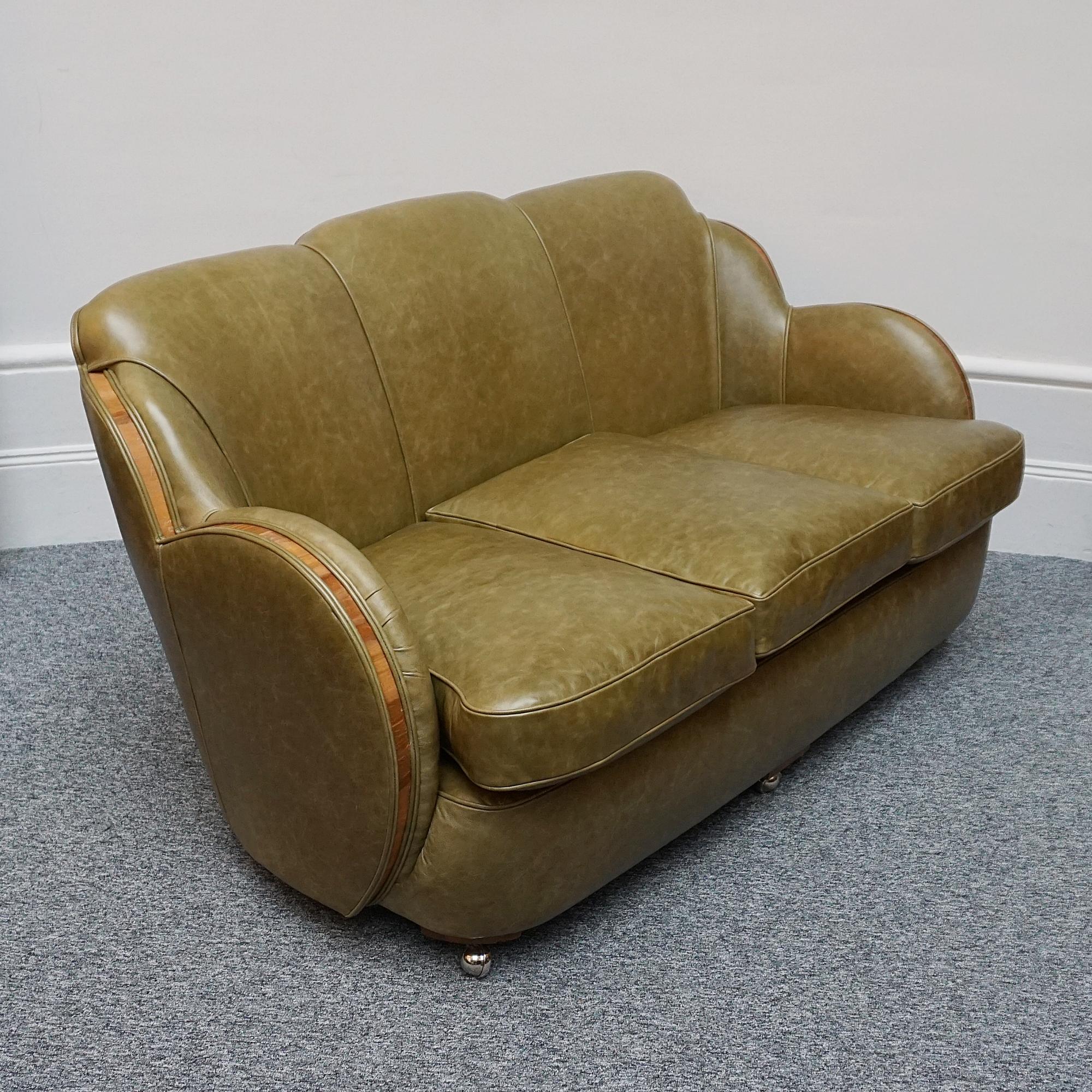 An Art Deco 'Cloud' Sofa by Harry & Lou Epstein. Three seater cloud back sofa with figured walnut show wood banding. Re-upholstered in olive green leather. 

Designer: Harry & Lou Epstein

Dimensions: H 85cm W 167cm D 93cm Seat H 48cm W 140cm D