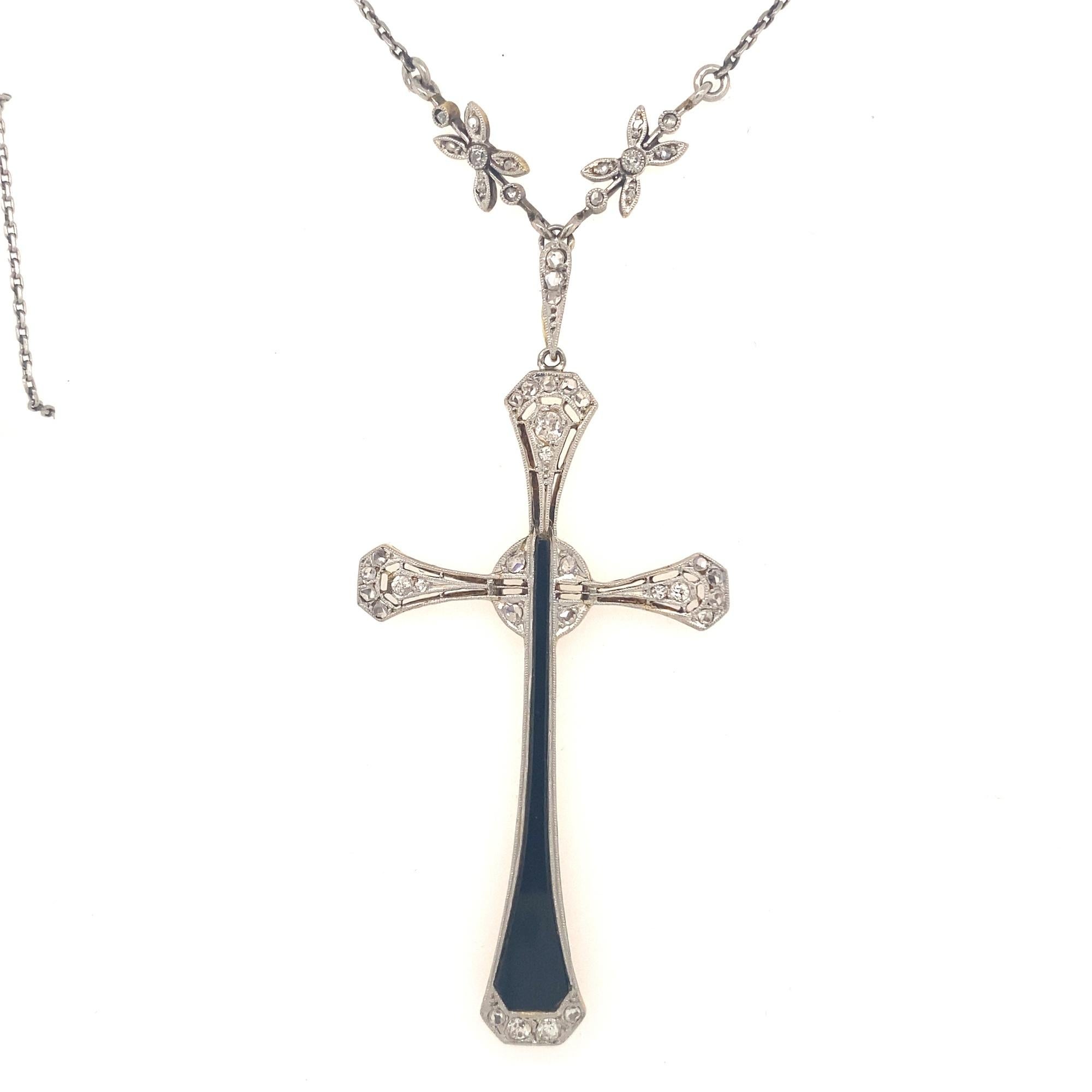 This is a beautiful original art deco cross C.1930 set with black onyx diamonds in platinum with an 18K gold back. The chain necklace has floral designs with 14 rose cut diamonds. The pendant has a large black onyx section with 30 old mine and rose