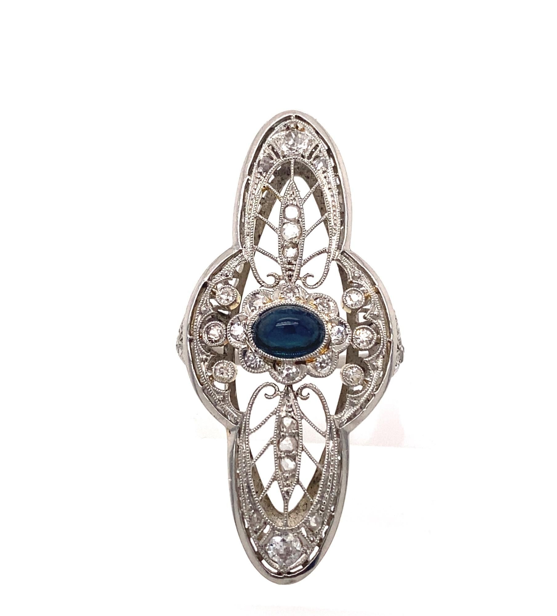 This is an amazing large late art deco ring set with an intricate filigree design. The ring is set with old mine and rose cuts diamonds and a cabochon blue sapphire.  The sapphire has amazing deep blue color and clarity approximately 1 carat.  There