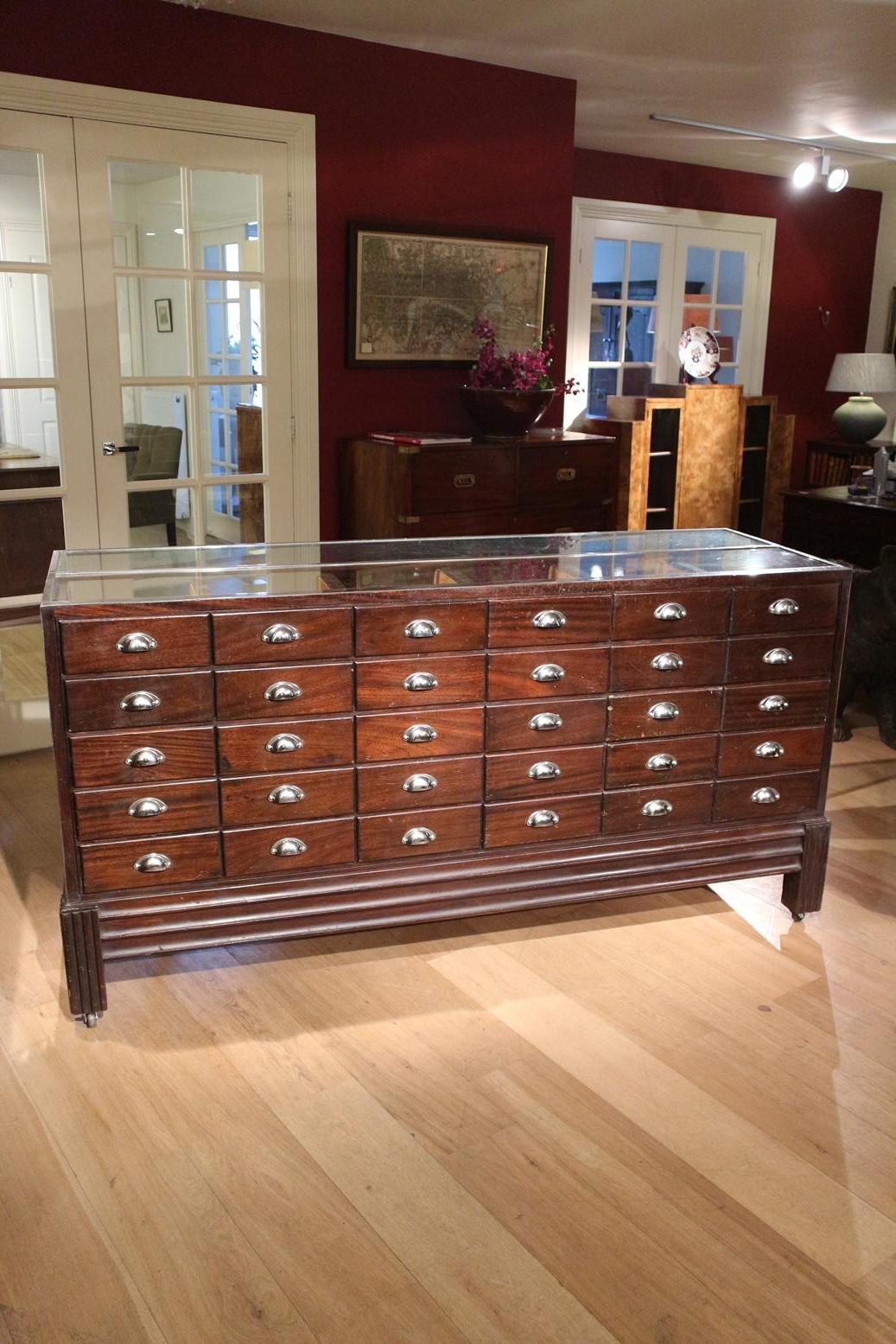 Special Art Deco mahogany / chrome counter / display case with 30 drawers. Entirely in original used condition. The counter is now temporarily on wheels for easy moving. Masterpiece of its kind!
Origin: England
Period: Approx. 1930
Size: W. 183