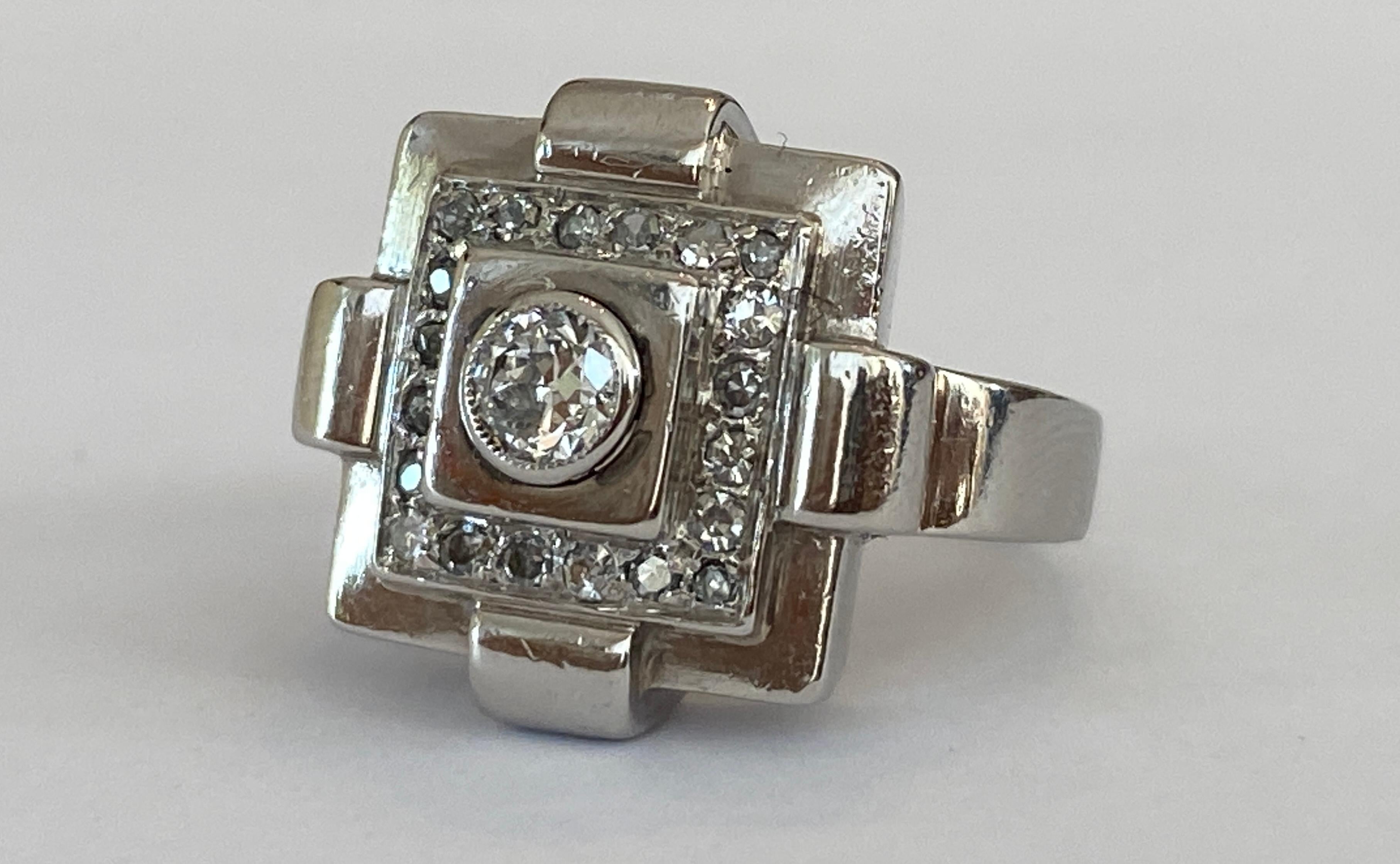 Offered original Art Deco ring in 18 kt white gold  with a typical four-lobed  ornamental piece set with a Bolshevik cut diamond approx 0.20 ct H/SI
and decorated  with 20 octagon cut diamonds approx 0.20 ct H/SI/P1.
The ring  has some  signs of