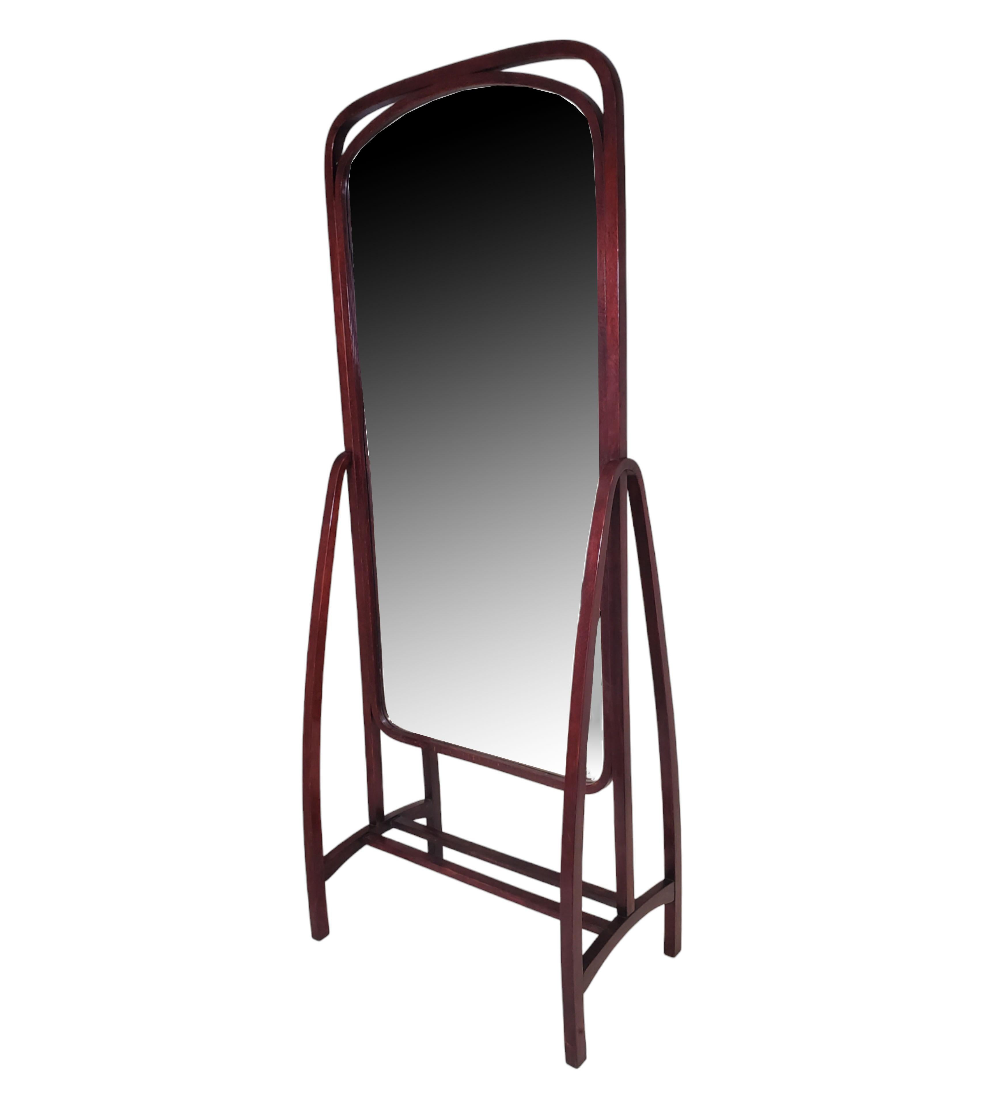 
Austrian, Wien full length dressing mirror in stained and polished beechwood with double curved bentwood surround extending the full length of the stand and culminating in a very unusual and elegant leggy base.
This standing mirror circa 1904 has