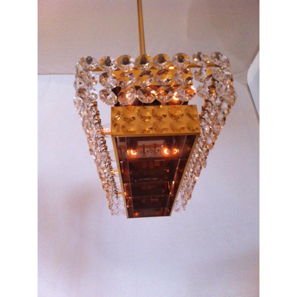 More than 130 hand-cut crystal prisms, gilded brass frame, a typical Viennese post-war work. Obviously made to illuminate a store counter.

The height is just the chandelier, the total drop of 112cm can be shortened. 
12