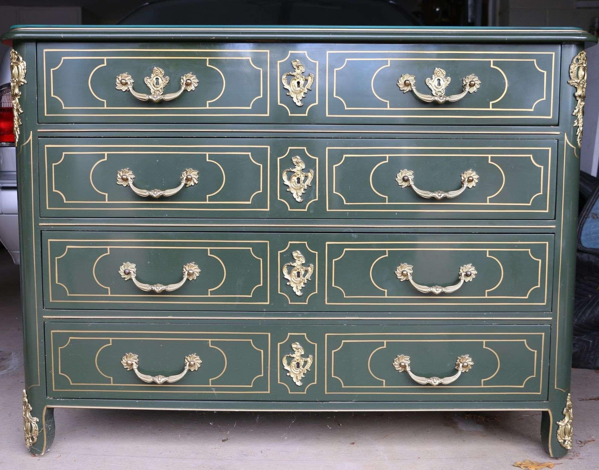 Baker Collector's limited edition hand painted green and gold lacquered four-drawer occasional chest of drawers. Painted wood with ornate gold-toned detailing. Includes a thin glass ogee edge top. Brass hardware and sabots on feet. Features four