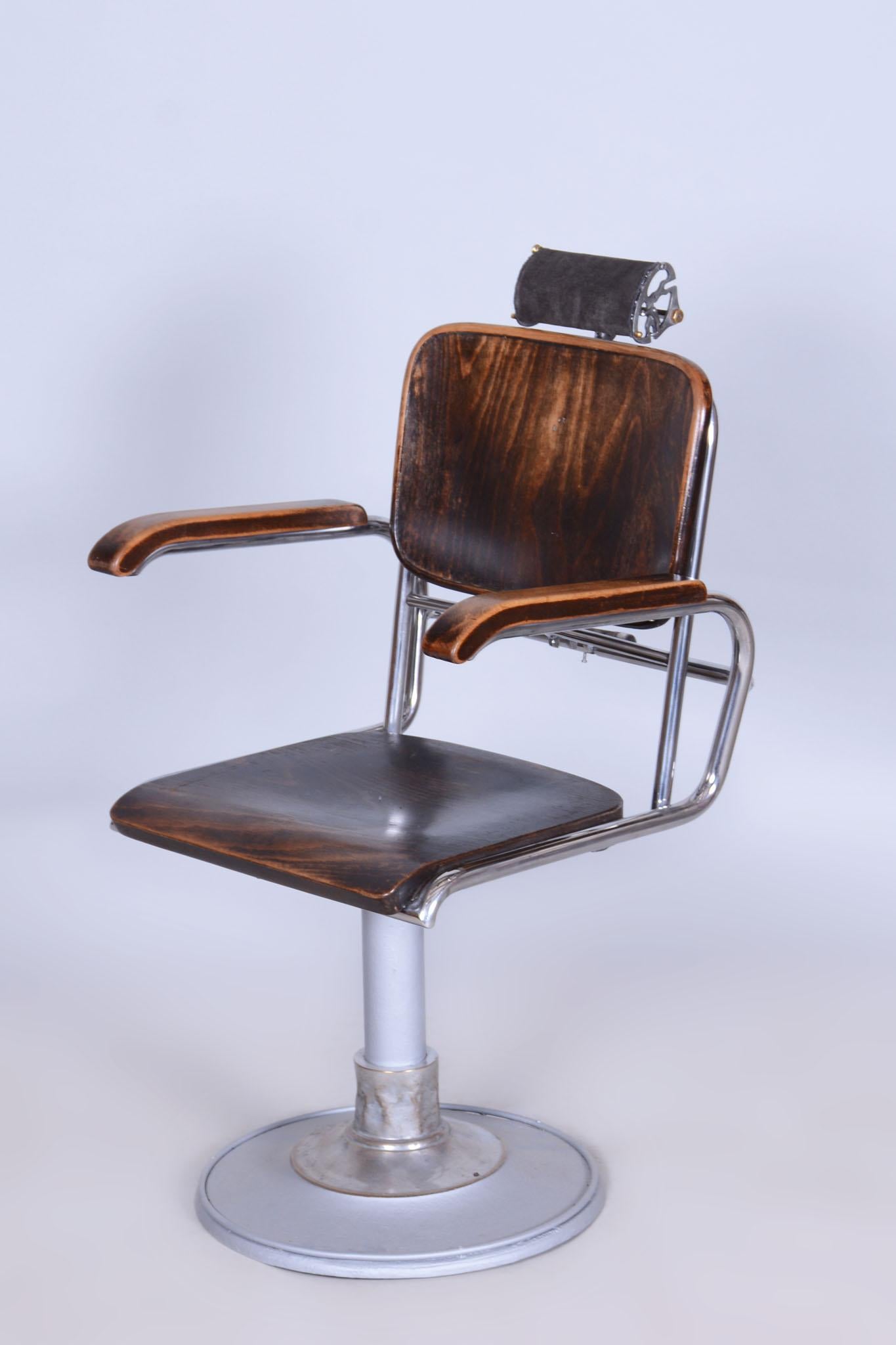 This iconic Bauhaus style barber chair comes from Czechoslovakia from the 1930s. It was manufactured by Mücke-Melder. The chair has a chrome steel frame and a seat, backrest, and armrests made of beech wood.

It is swiveling and reclining and has