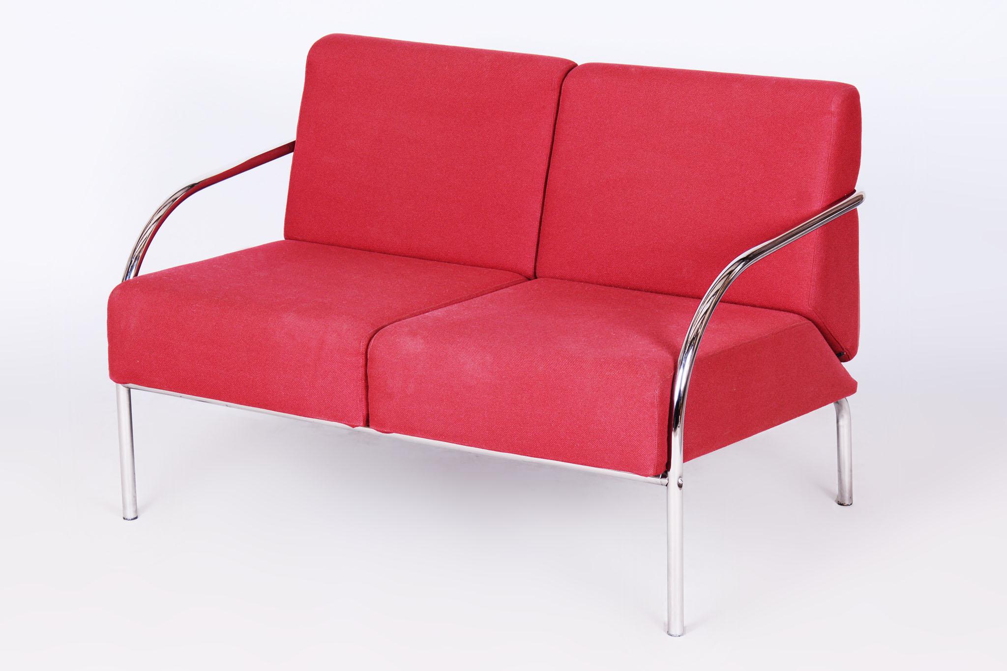 Cette causeuse (canapé à deux places) du Bauhaus datant de la seconde moitié du XXe siècle est un excellent exemple de design fonctionnaliste intemporel. Le cadre est en acier tubulaire chromé, ce qui lui confère à la fois légèreté et durabilité. La