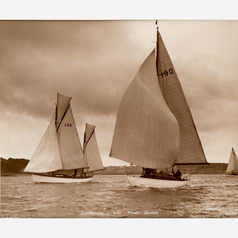 An original Beken image of the Gaff rigged Ketch sunshine (sail no 298) and the Bermudian rigged yacht Mary Bower (sail no 190) both on Starboard tack running down the Isle of Wight shore towards Cowes with Gurnard in the background,
circa
